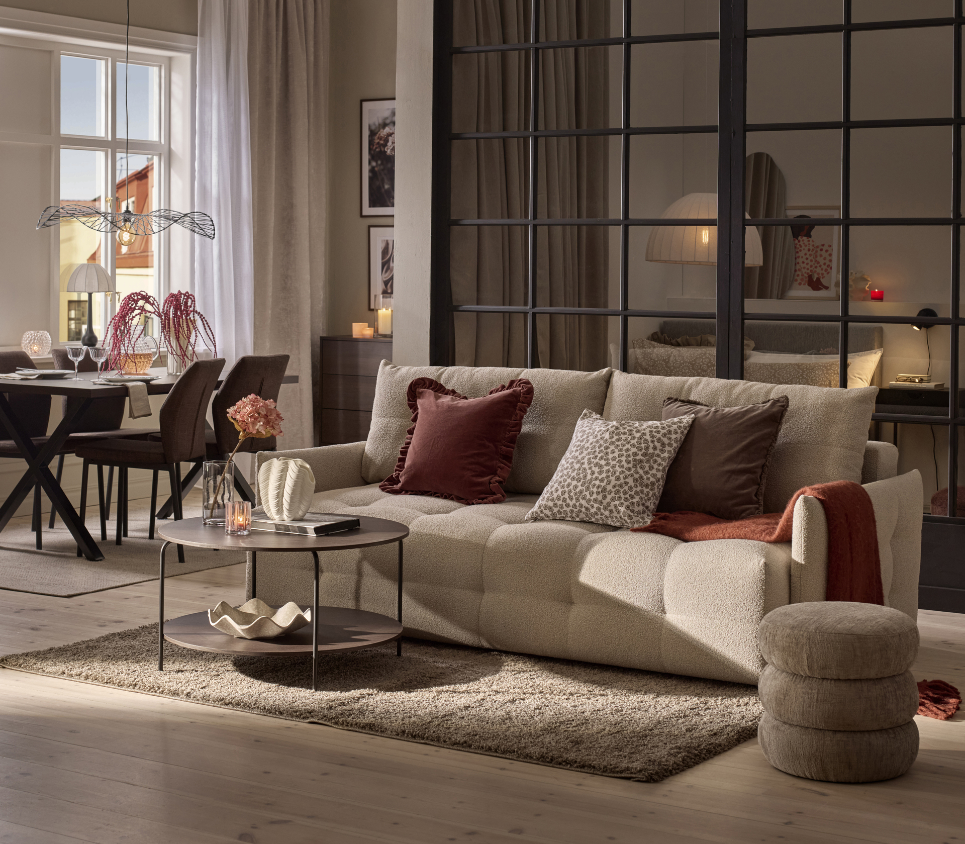 En beige bella bäddsoffa står i ett vardagsrum som går i beige, brunt och vinrött