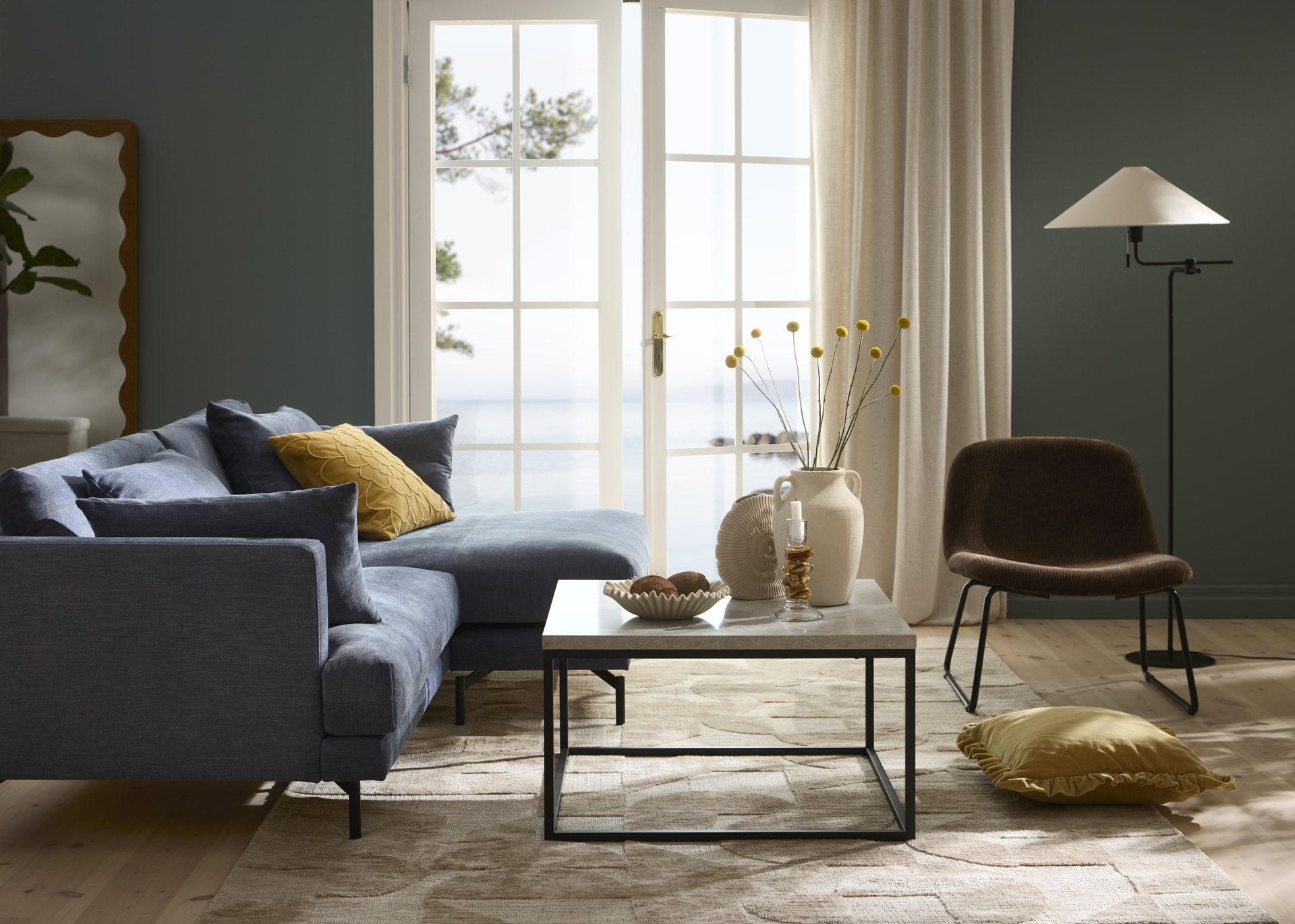 I ett stilrent vardagsrum står en blå soffa med raka former