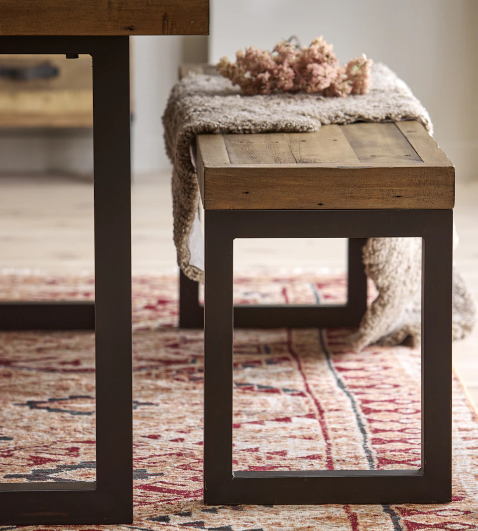 Detaljbild på bänk till matbord i rustikt trä.