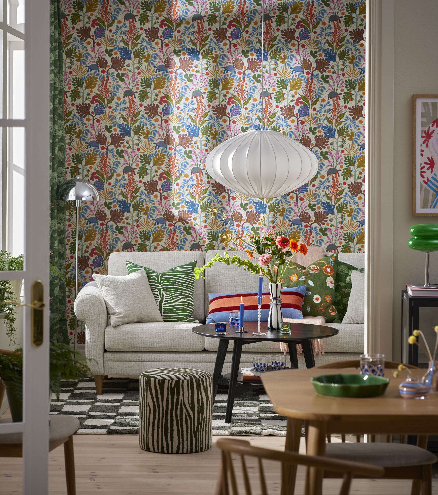 I ett kulört vardagsrum står en ljusgrå soffa 