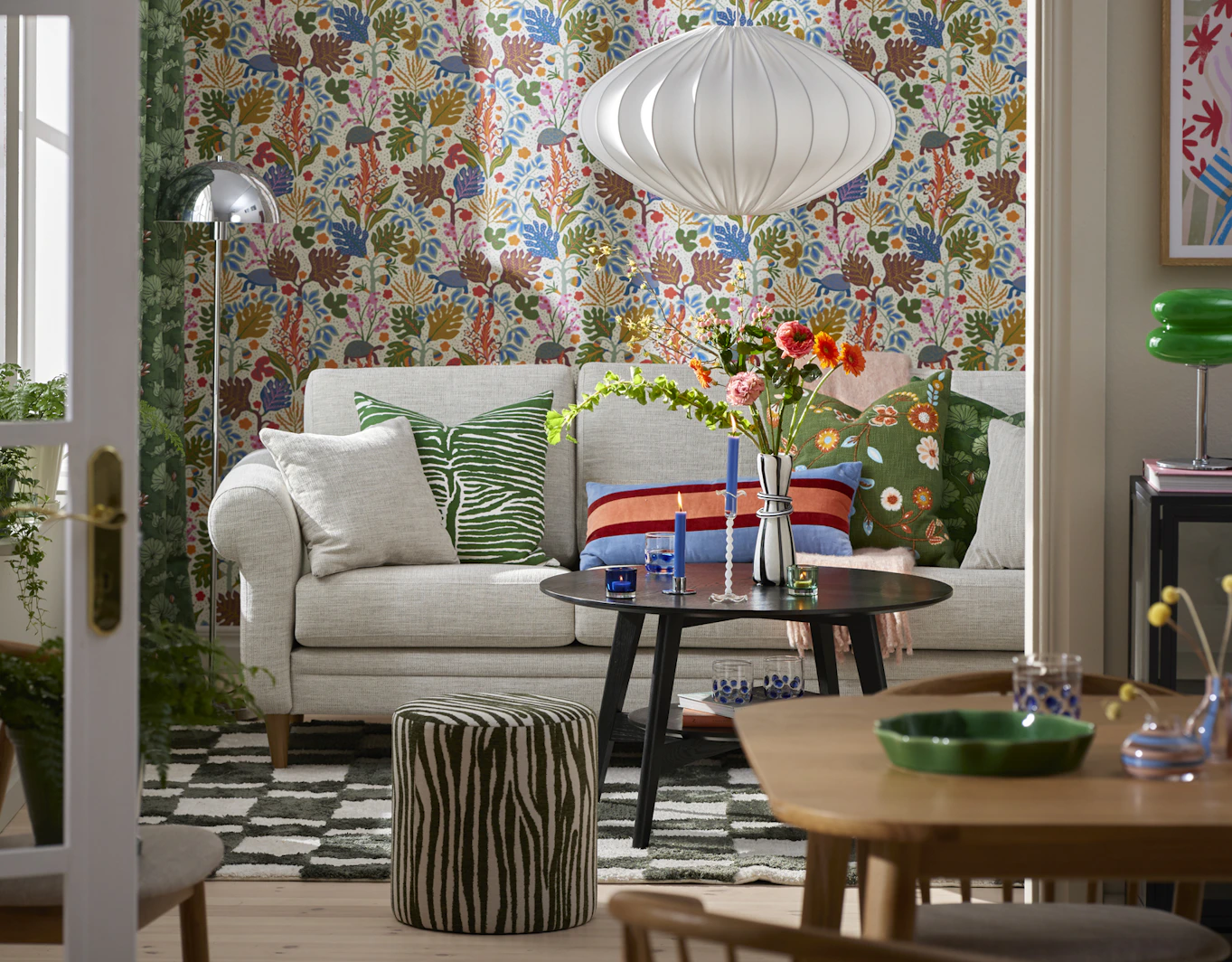 I ett kulört vardagsrum står en ljusgrå soffa