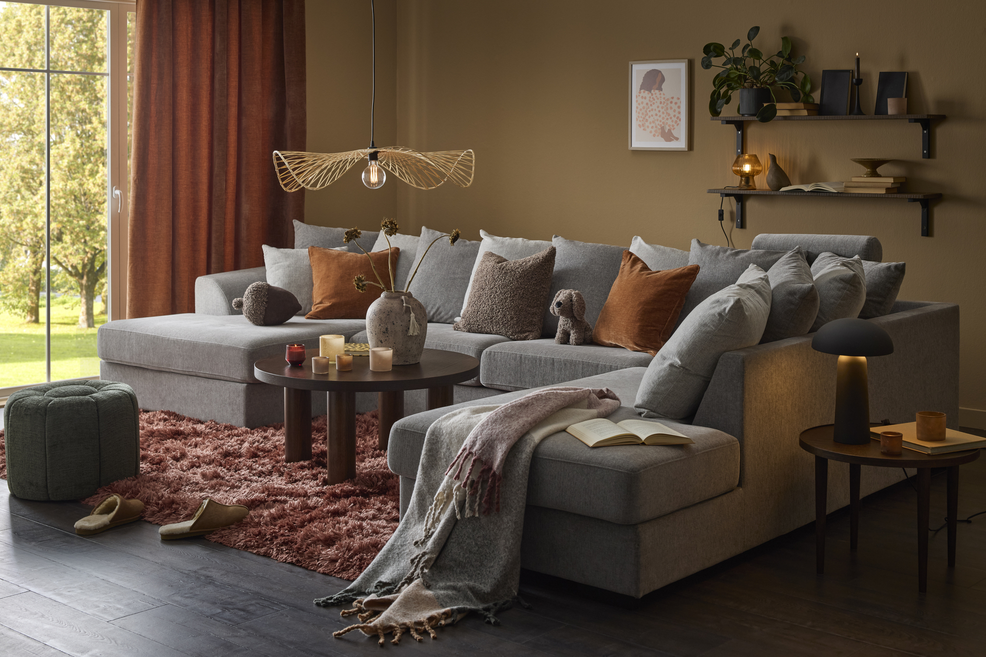 I ett ockragult vardagsrum står en stor, grå soffa med både divan och schäslong