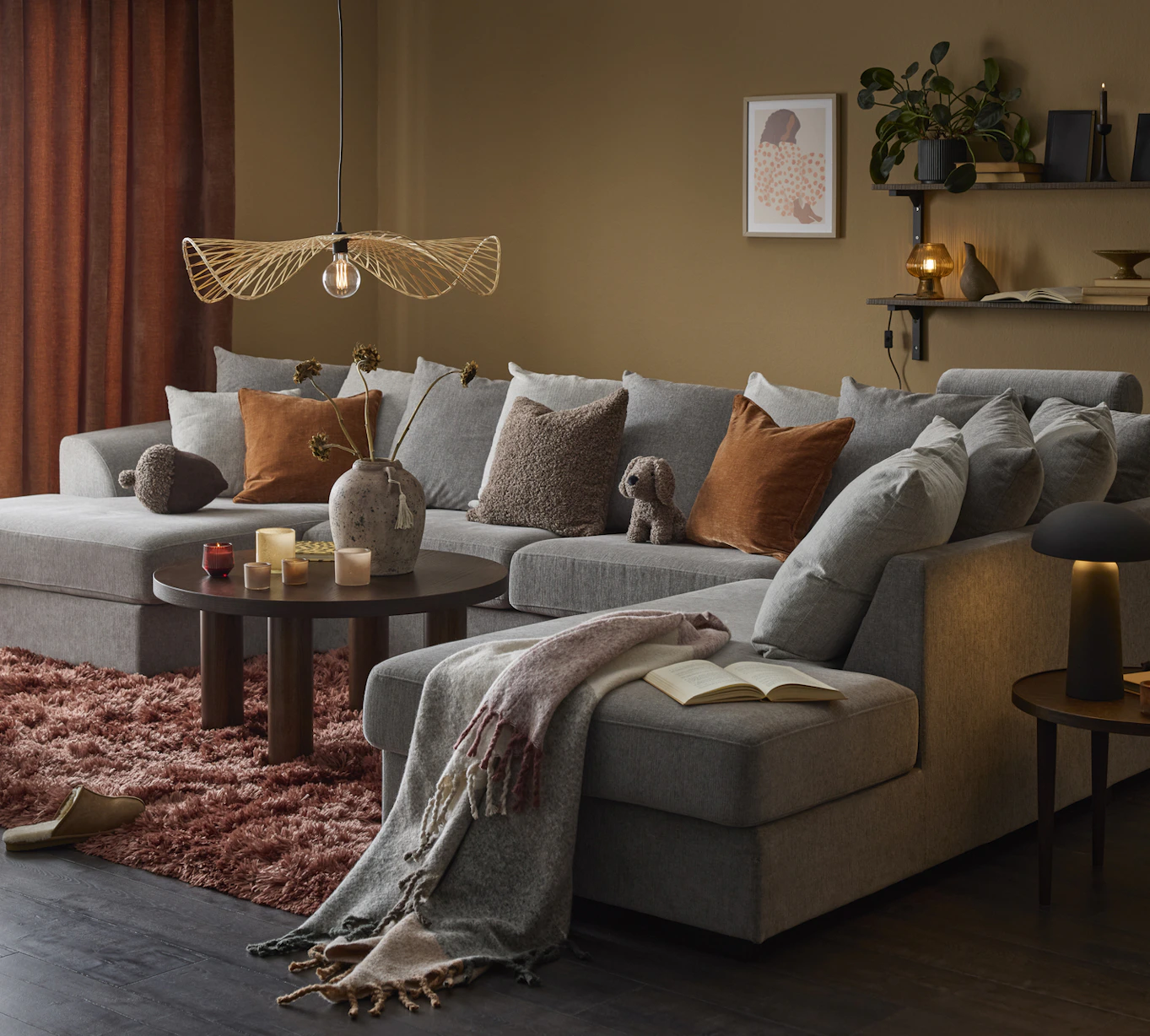 I ett ockragult vardagsrum står en stor, grå soffa med både divan och schäslong