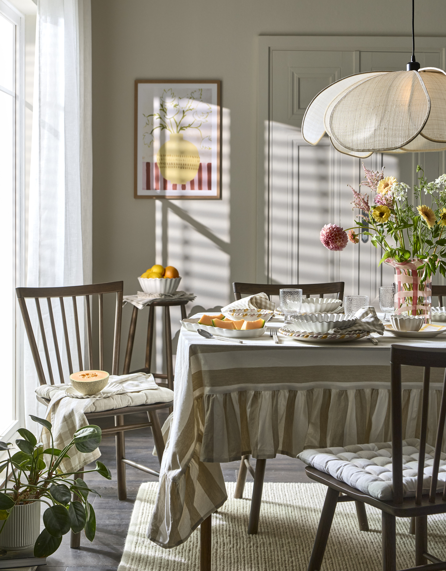 En matgrupp i mörkt trä är dukat med en randig duk och ljust porslin.