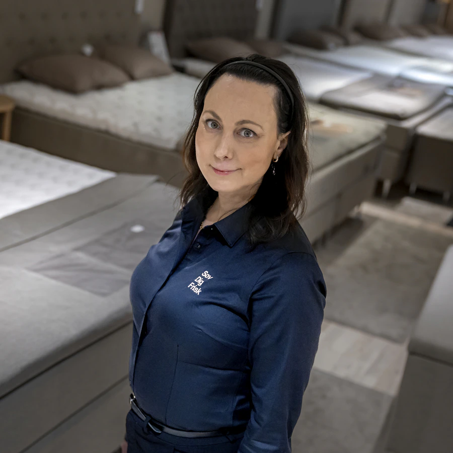 Sömnforskaren Claire Anne Eriksen står framför en rad sängar