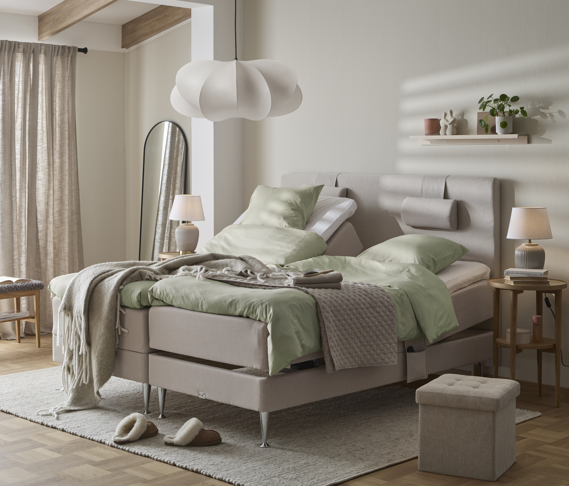 I ett ljust sovrum står två ställbara sängar med gröna sängkläder.