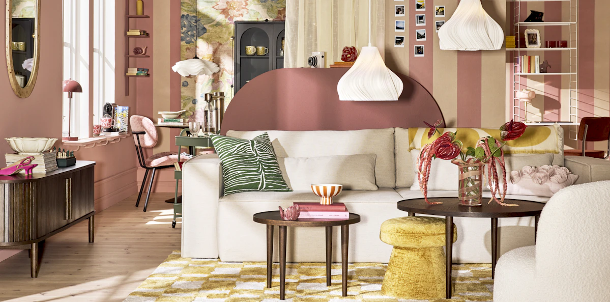 En vit djup soffa står i ett färgglatt vardagsrum