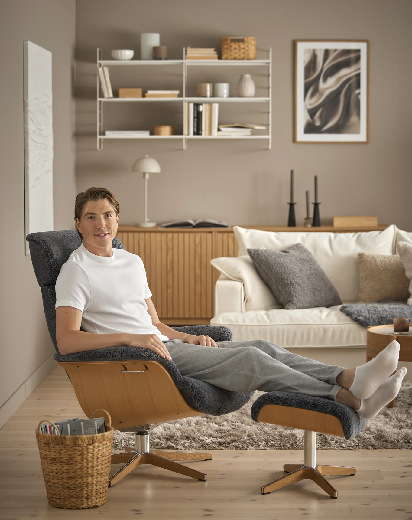 Skidåkaren William Poromaa sitter avslappnat i en fårskinnsfåtölj med fötterna på en fotpall.