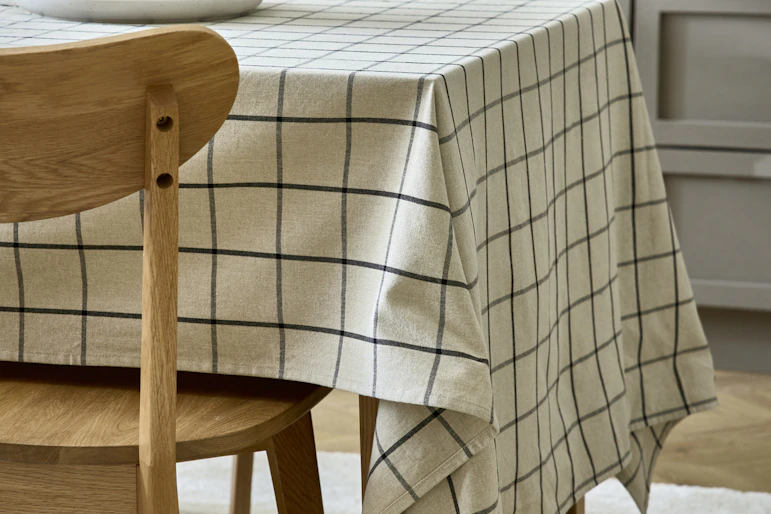 en rutig duk ligger på ett bord i ett kök