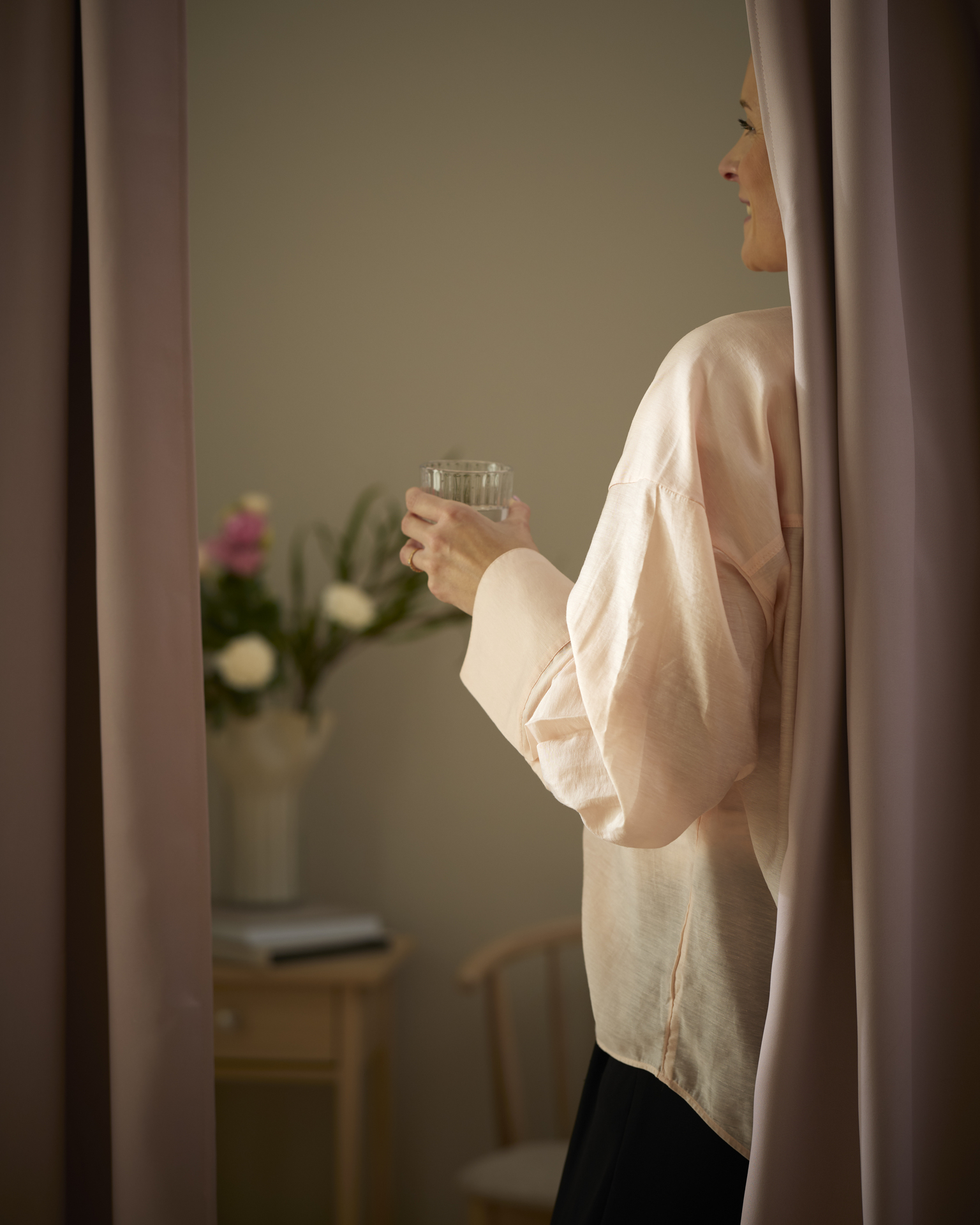 kvinna står bakom en gardin i sammet