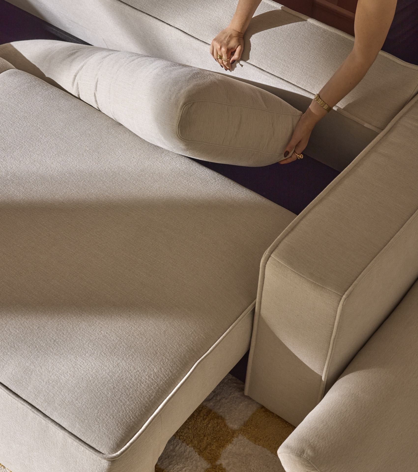 En bild som illustrerar att det finns förvaring under ryggen på bäddsoffan