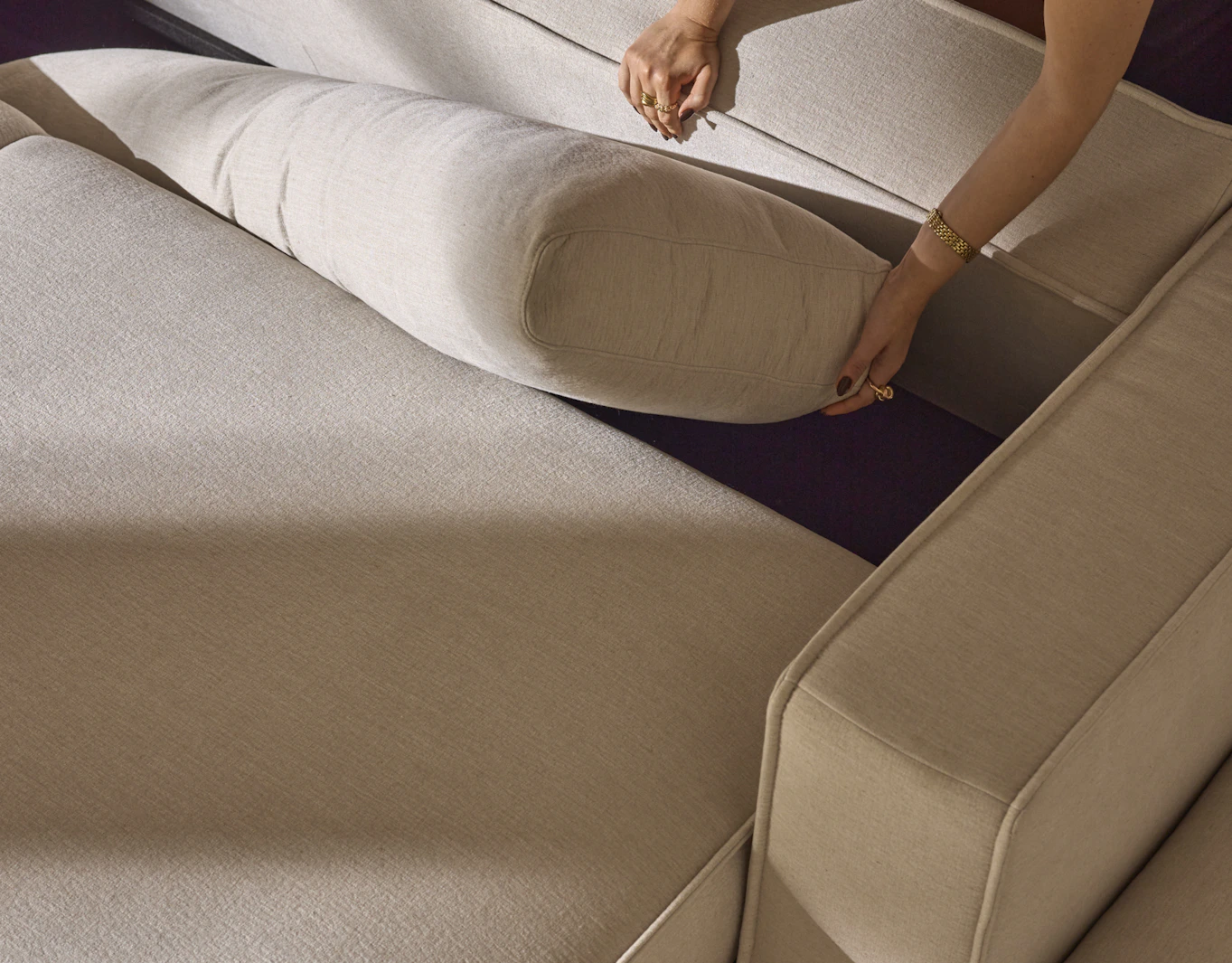 En bild som illustrerar att det finns förvaring under ryggen på bäddsoffan