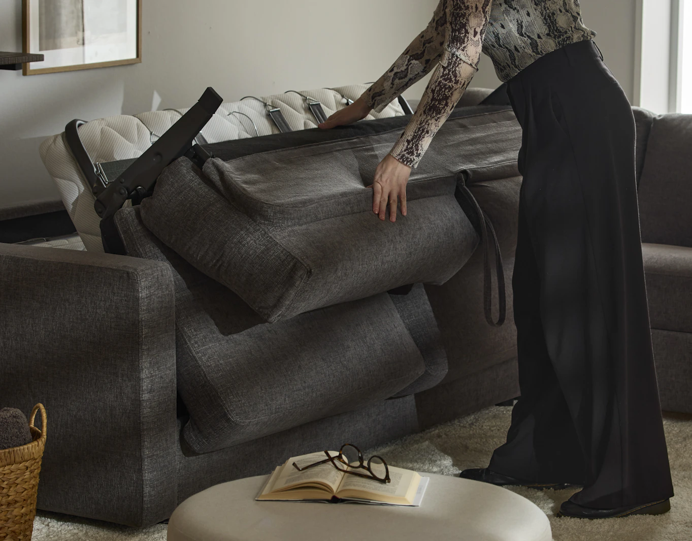 En kvinna illustrerar hur smidigt man bäddar in och ut en klassisk bäddsoffa