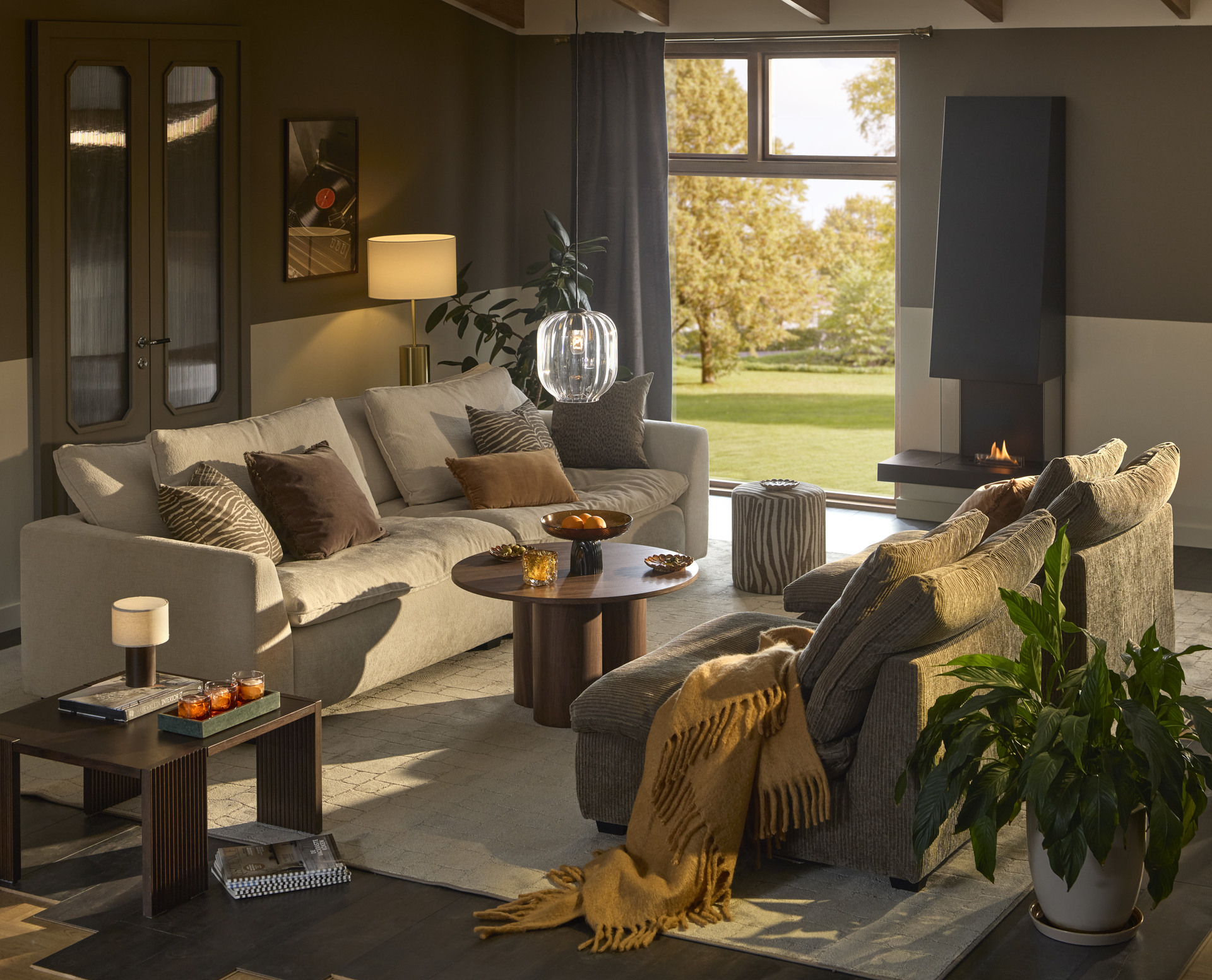 Ett vardagsrum där det står en stor beige soffa mittemot två mörkare fåtöljer.