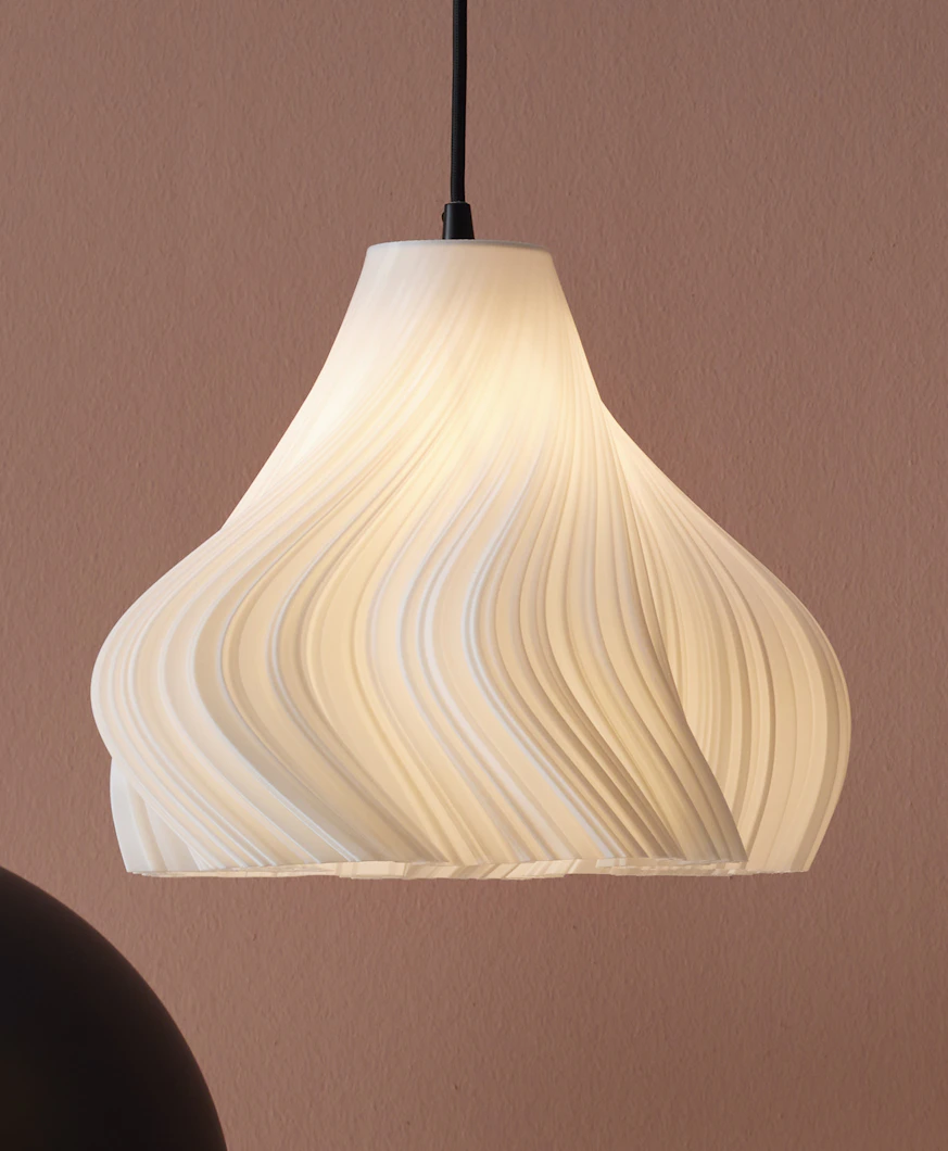 en vit taklampa hänger ned framför en rosa vägg