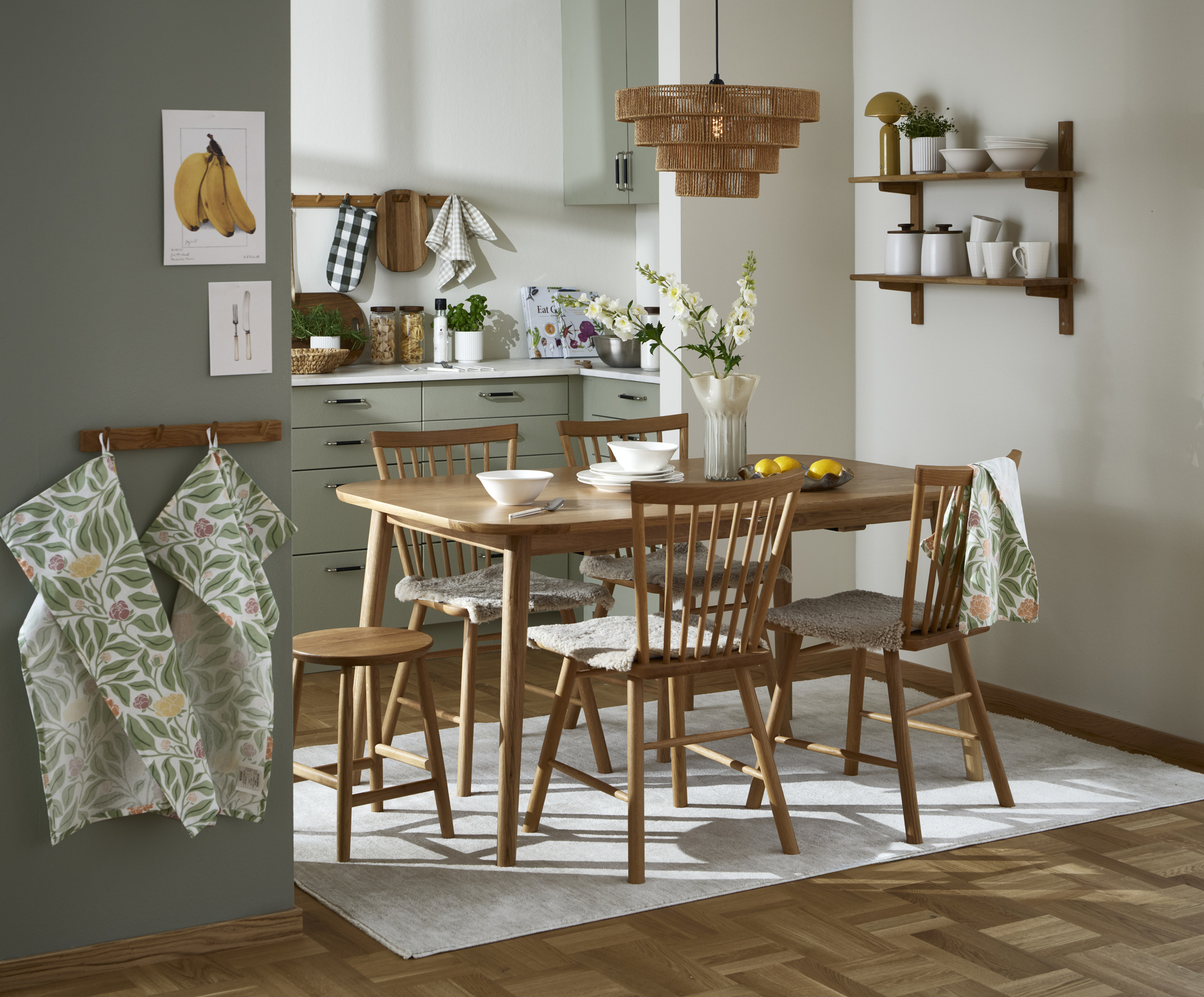 I ett kök i beiga toner står en matgrupp för fyra i ljust trä