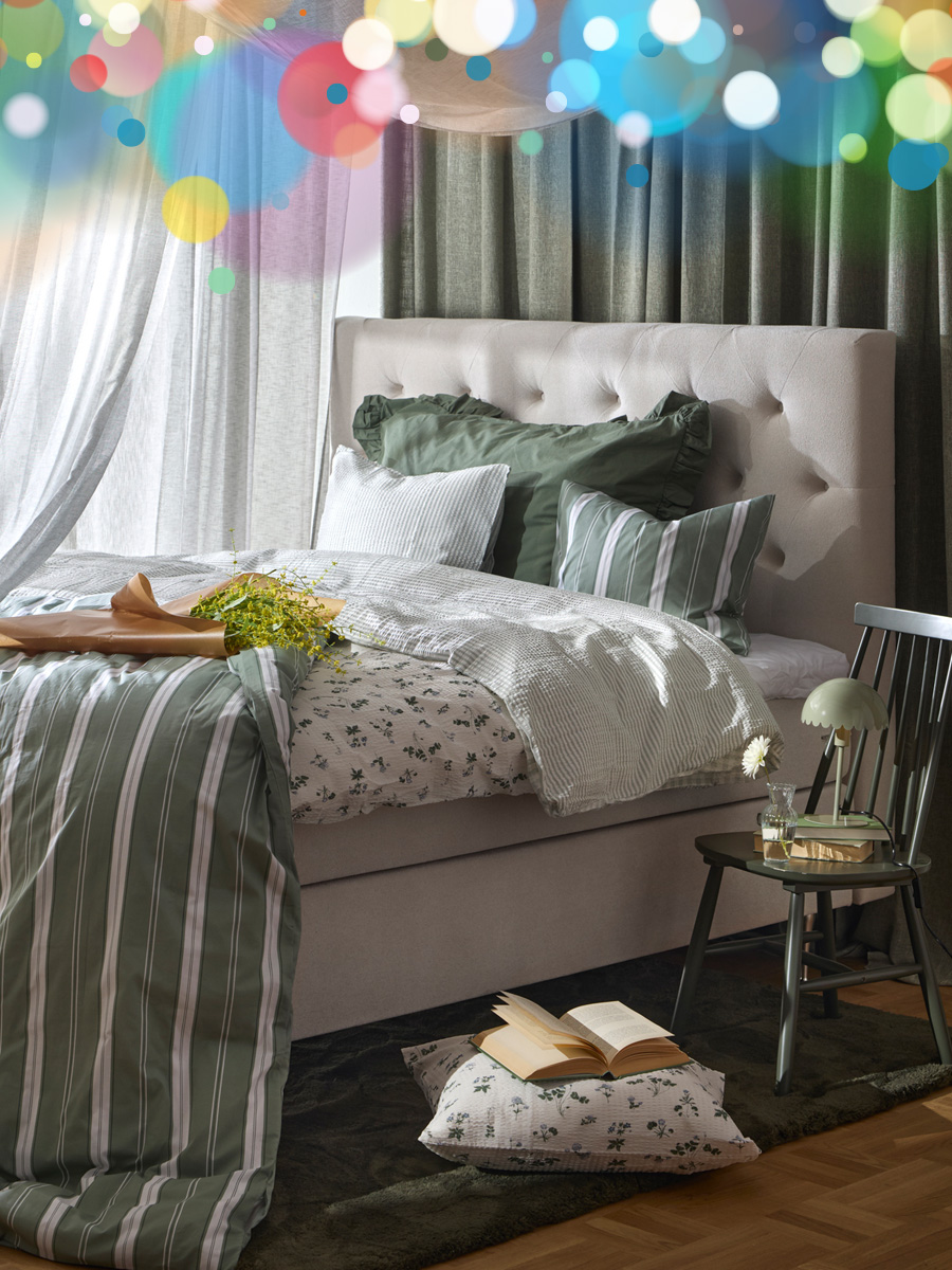 en beige säng bäddad med vita och gröna påslakanset