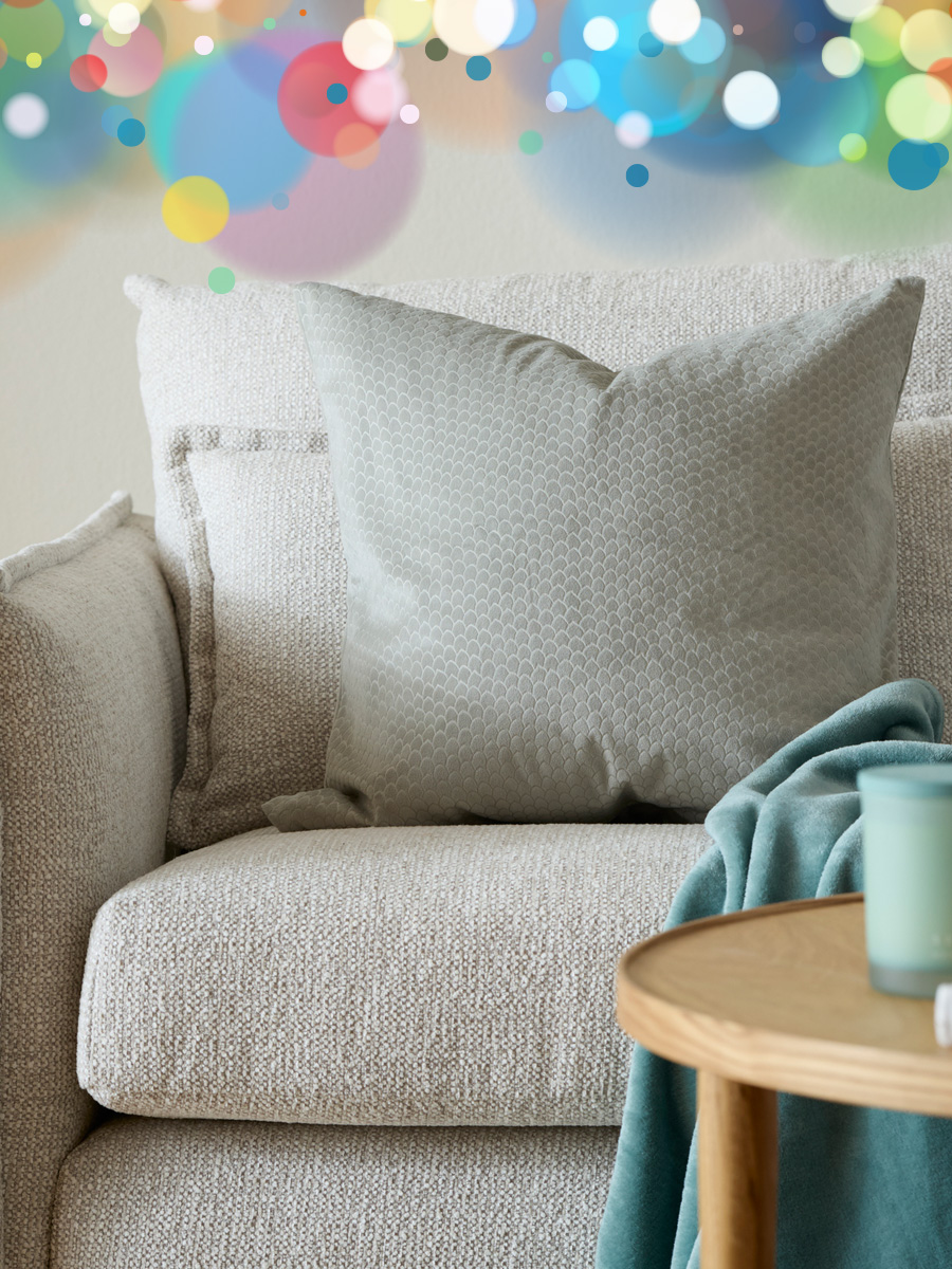 en grön kudde står i en grå soffa