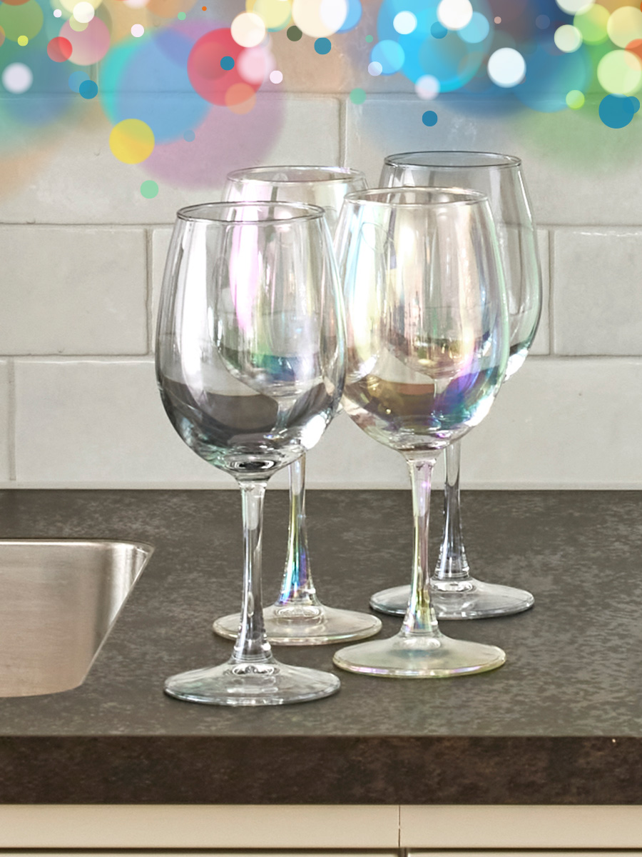 fyra vinglas står på en köksbänk med vitt kakel i bakgrunden