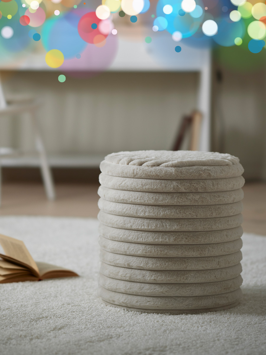 en fluffig beige puff står i ett vardagsrum på en vit matta