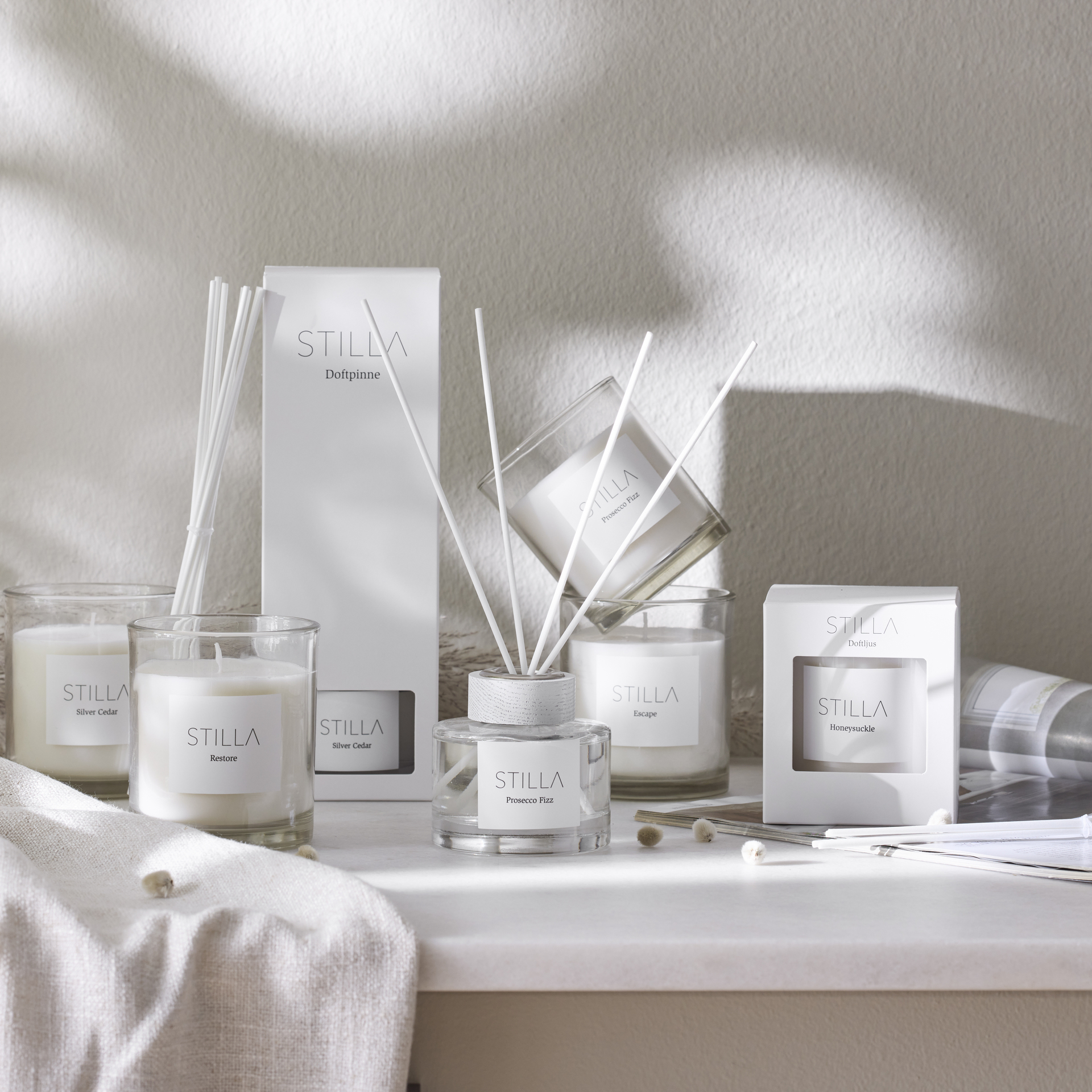 Doftpinnar och doftljus står uppställda på en bänk