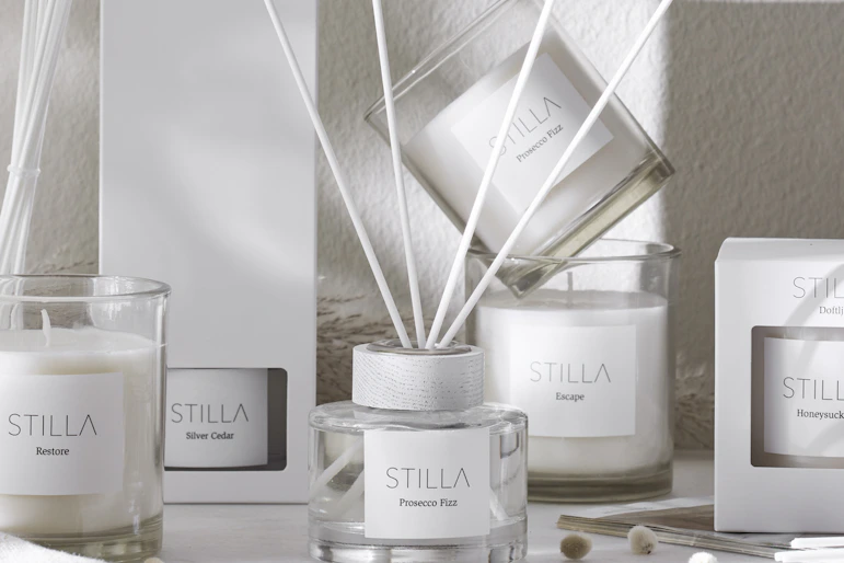 Doftpinnar och doftljus står uppställda på en bänk