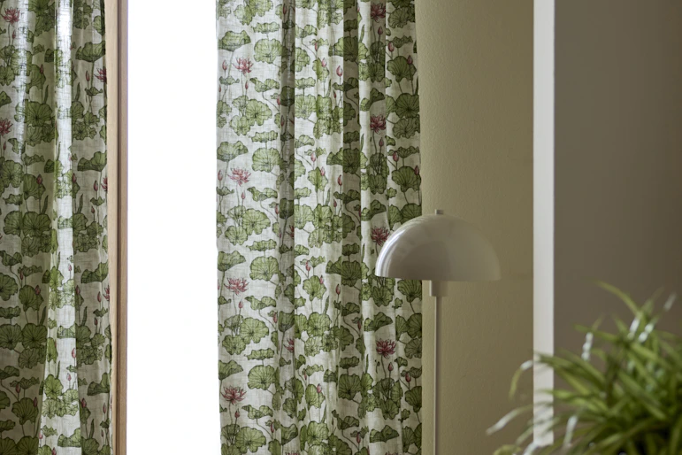 grönmöstrade gardiner hänger framför ett stort fönster