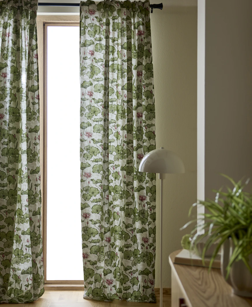 grönmöstrade gardiner hänger framför ett stort fönster