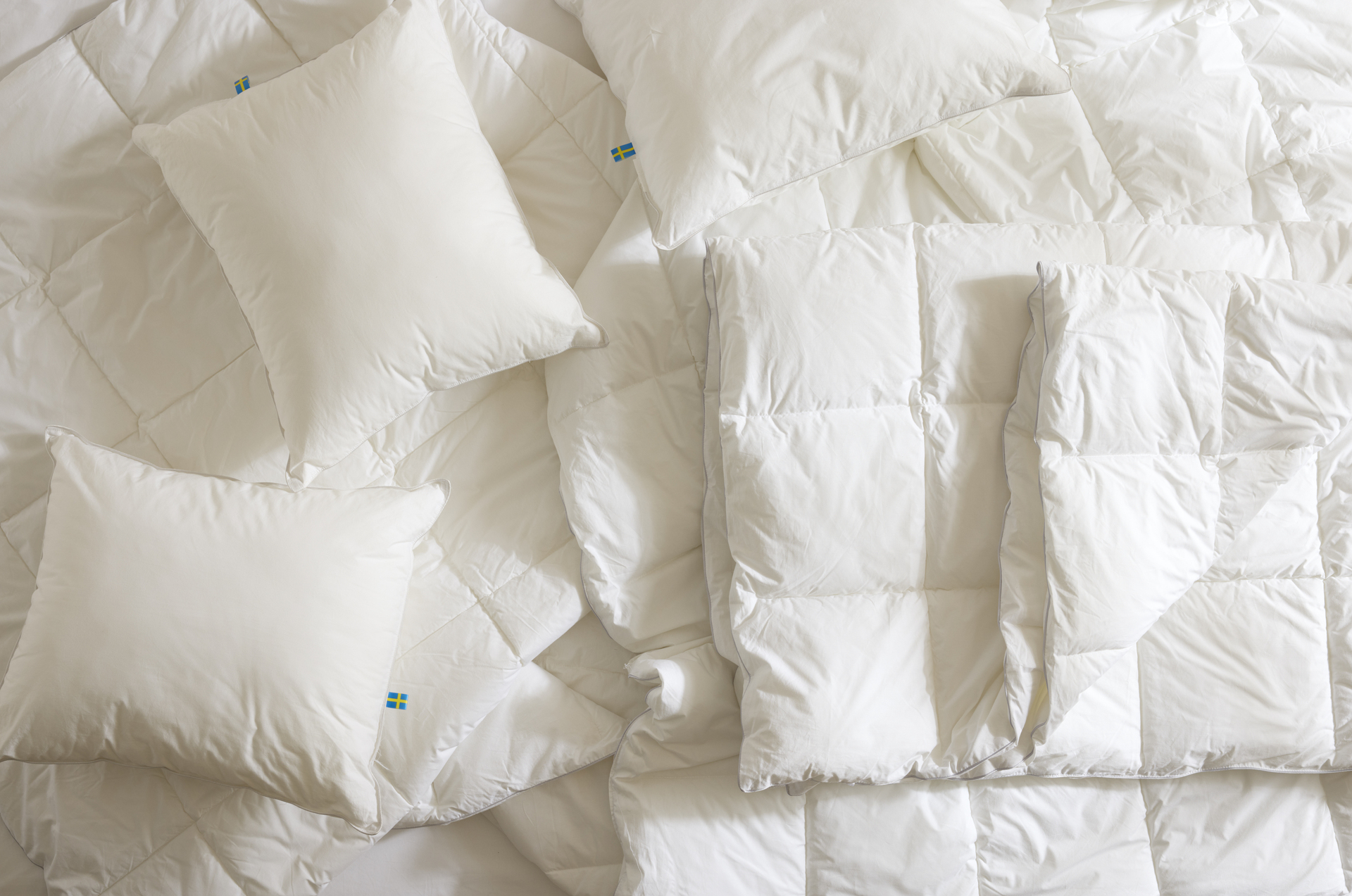 Täcken och kuddar ligger i en obäddad säng.