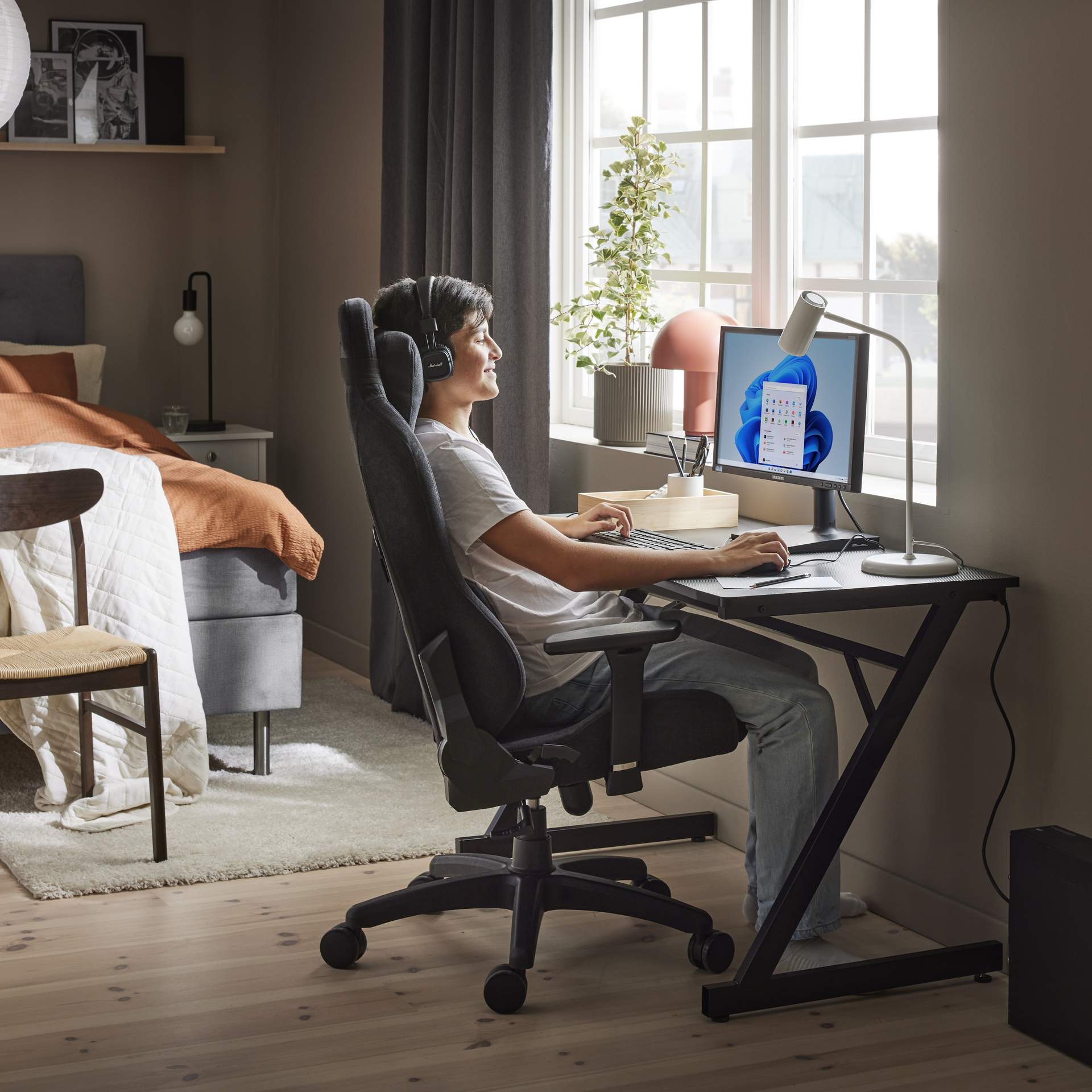 en kille sitter och spelar vid ett skrivbord