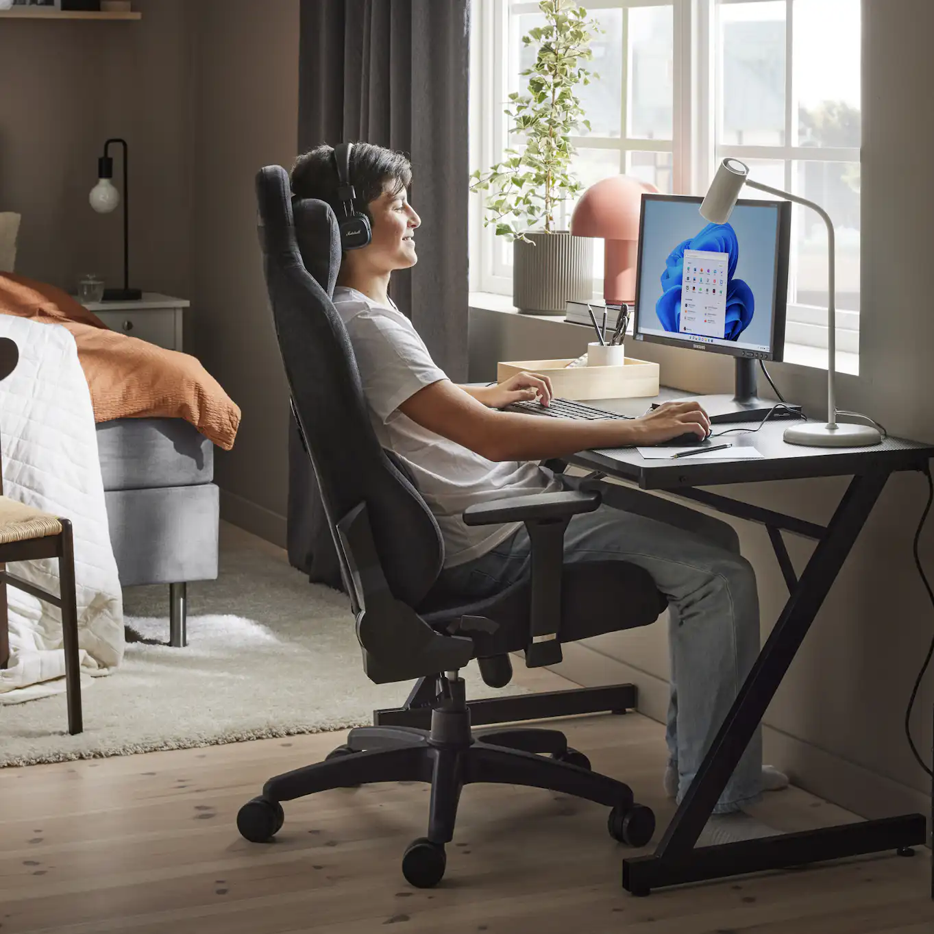 en kille sitter och spelar vid ett skrivbord