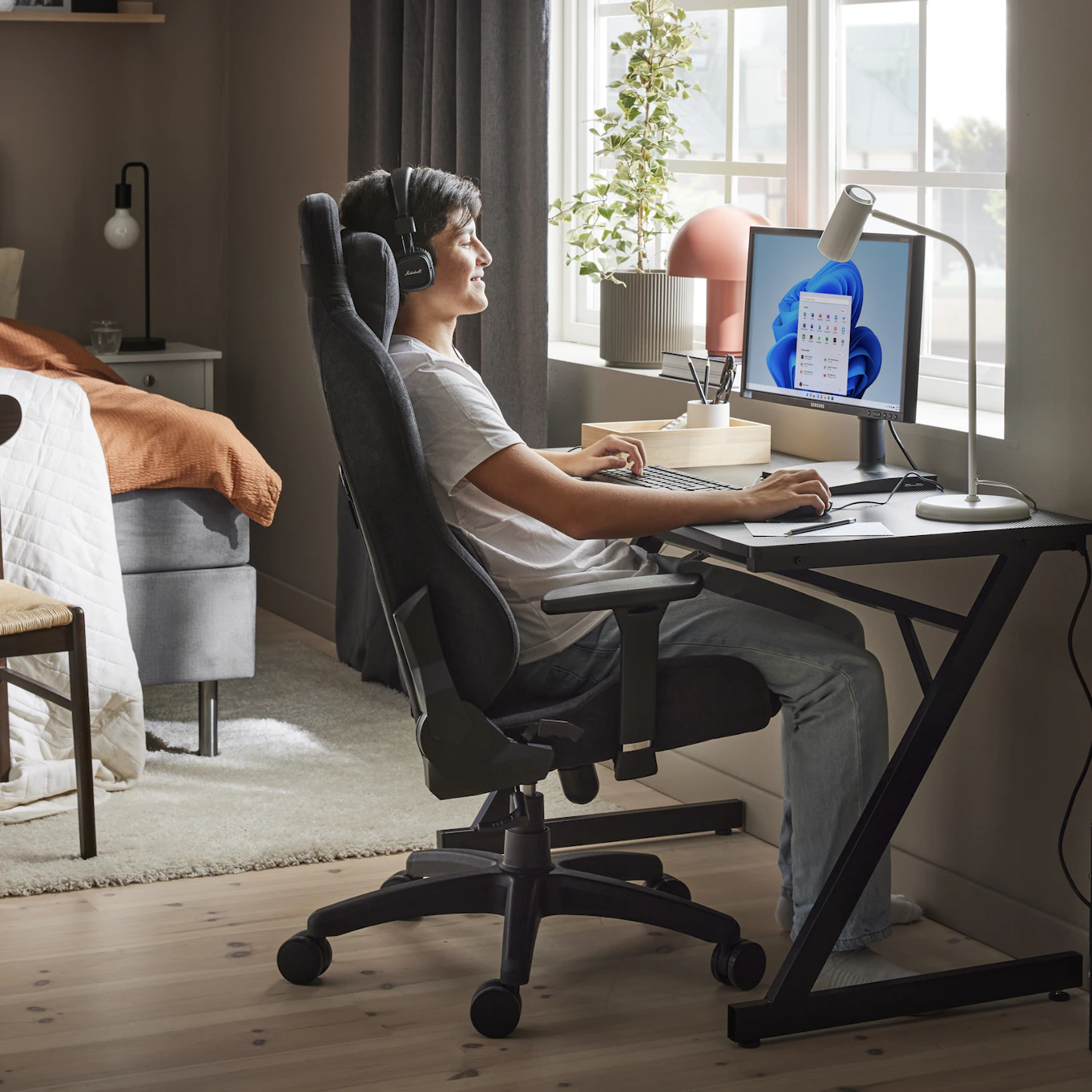 en kille sitter och spelar vid ett skrivbord