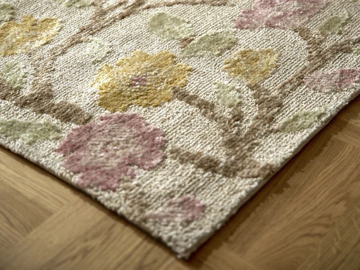 Matta i blommigt mönster med fårskinnstofflor på i bakgrunden