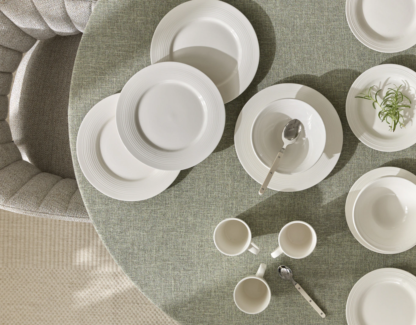 En bild fotat ovanifrån på ett bord med grön duk och servisen Bianca.