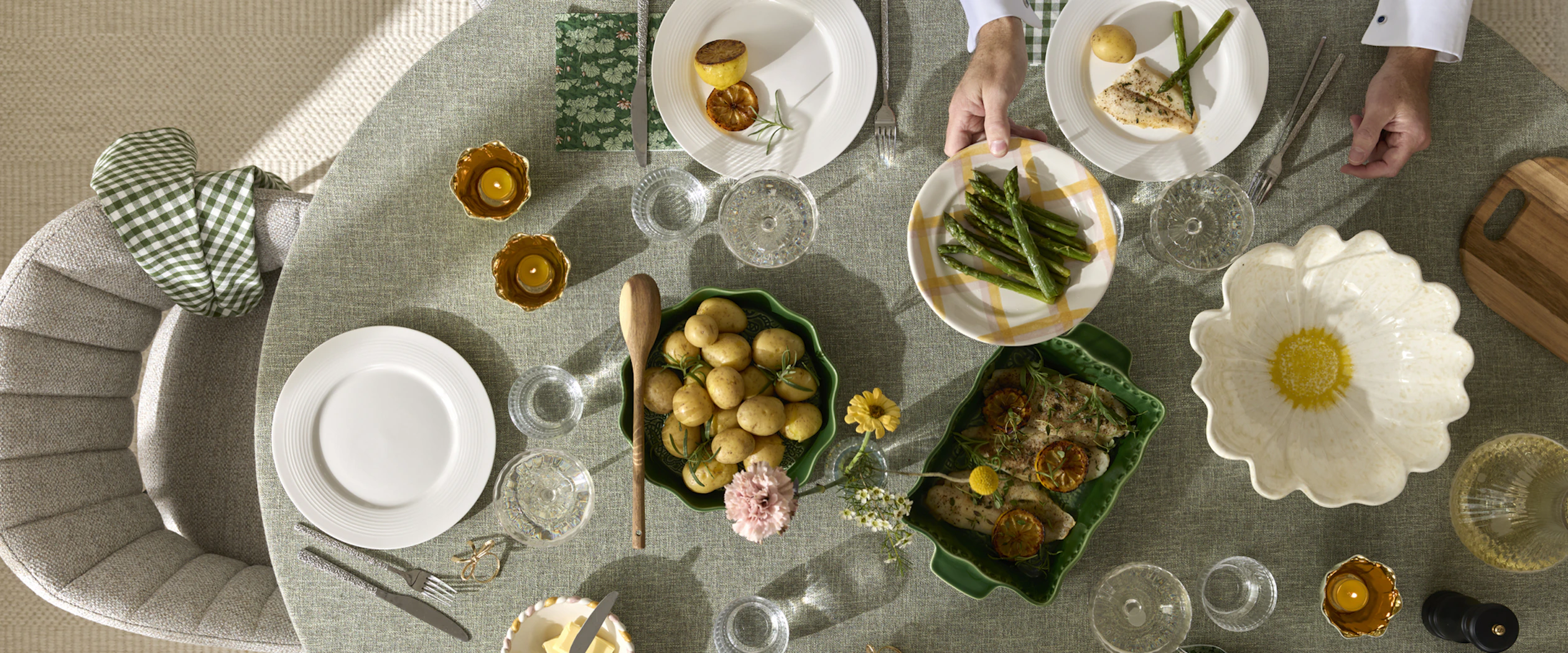 ett bord med en grön duk är dukat med porslin i olika färger och mat i skålar och på fat