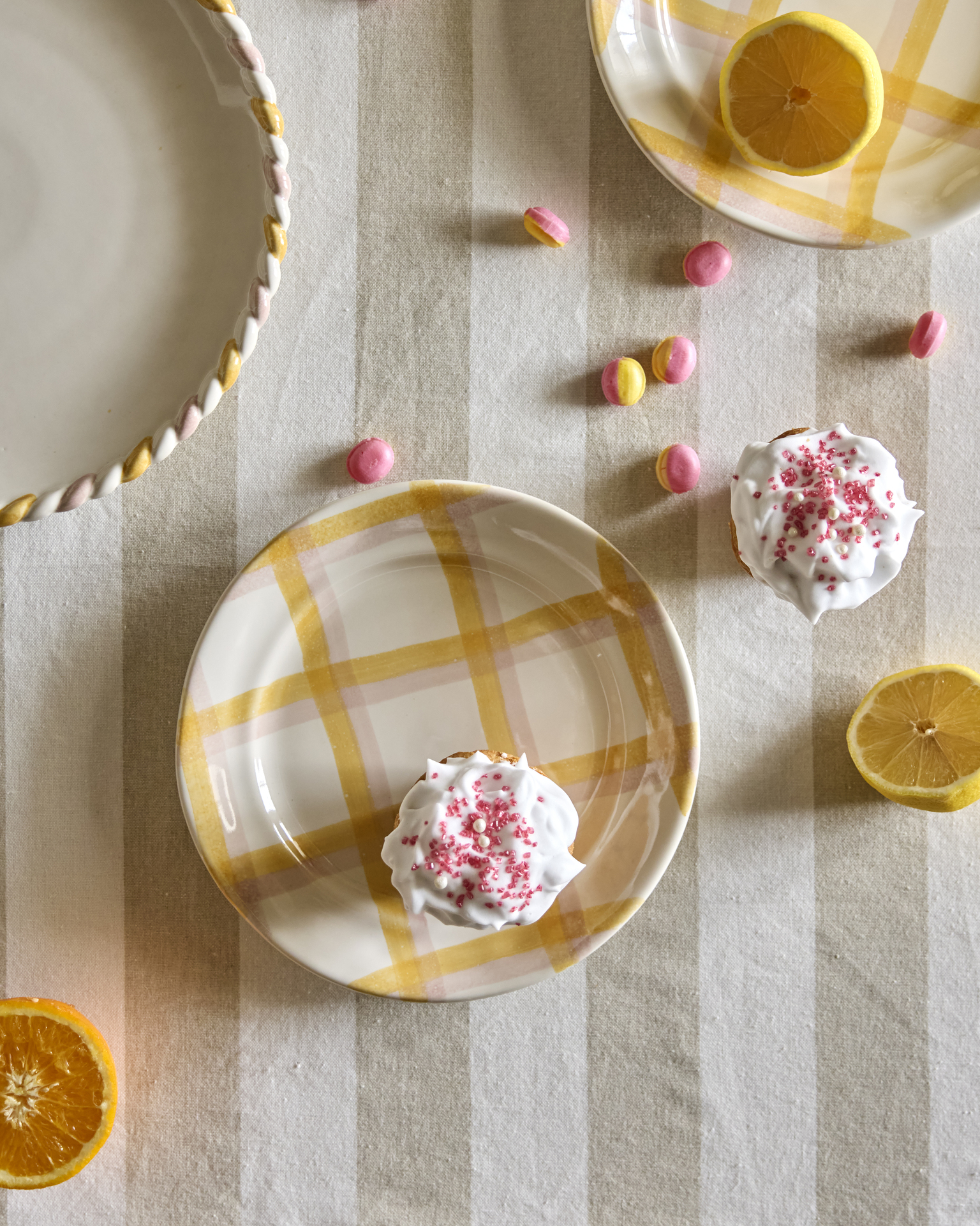 en muffins ligger på en gul-rutig tallrik på en randig duk