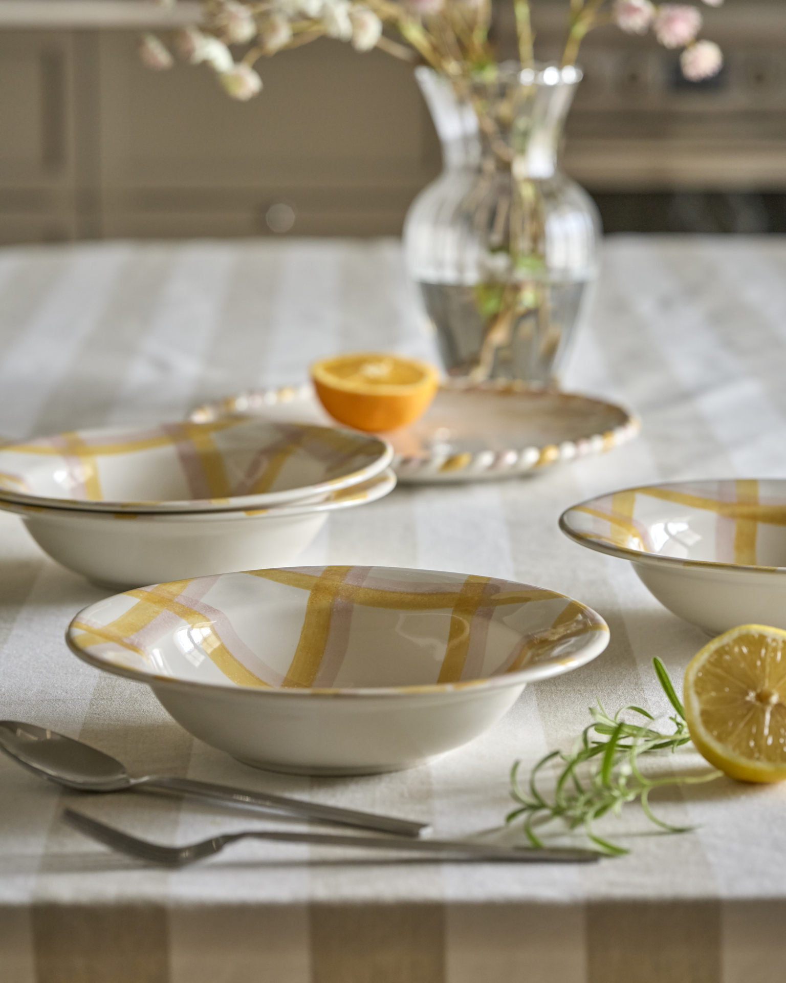 gulmönstrat porslin i olika former står på en randig duk