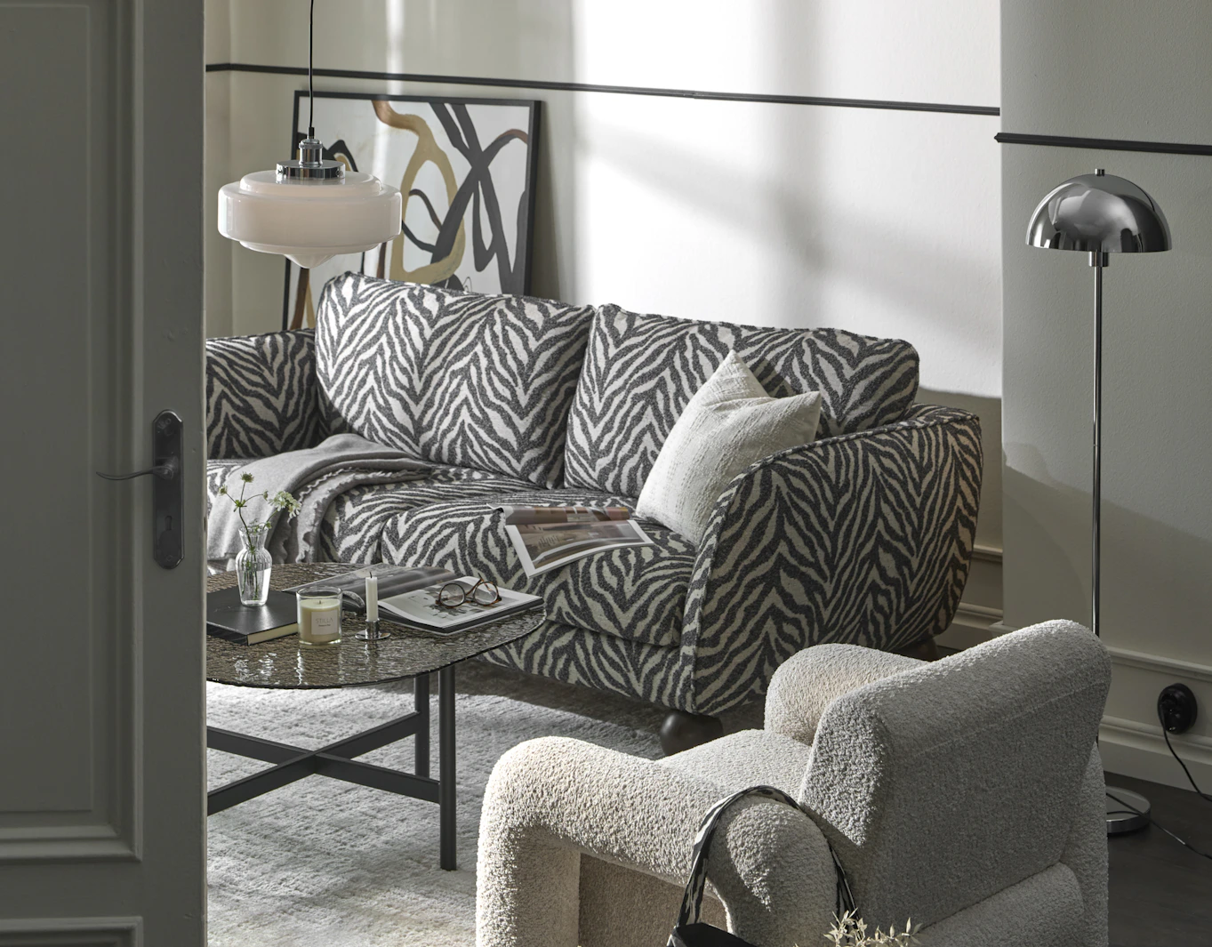 I ett stilrent vardagsrum står en zebramönstrad soffa