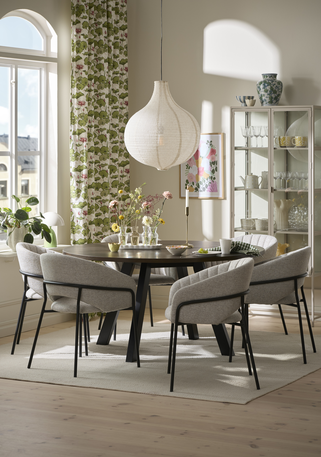 En matgrupp står framför ett fönster med gardiner med grönt mönster