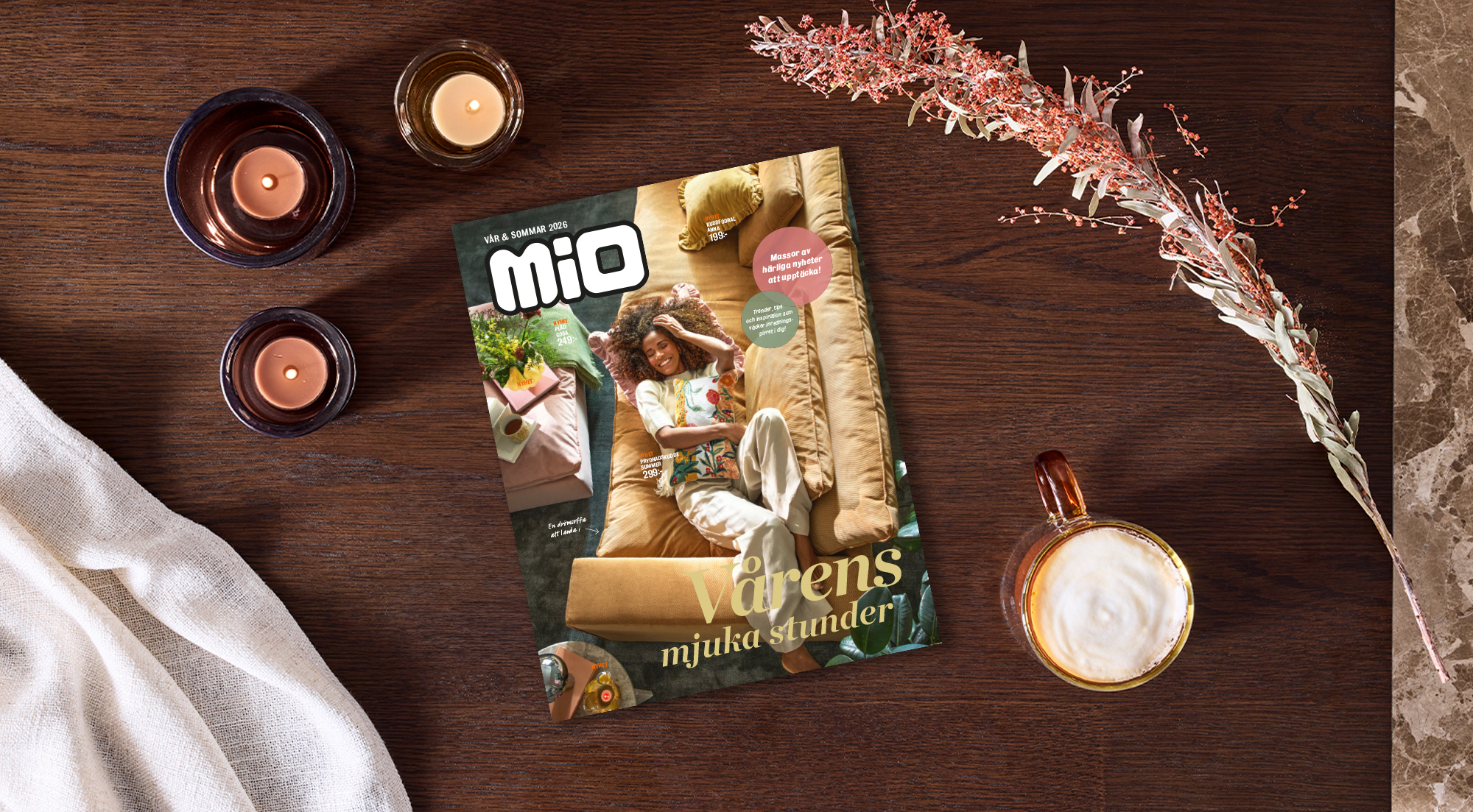 På ett bord i mörkt trä ligger Mios katalog för våren 2026