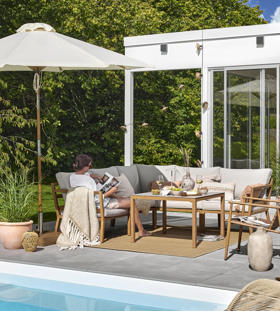 en loungegrupp står på en uteplats intill en pool