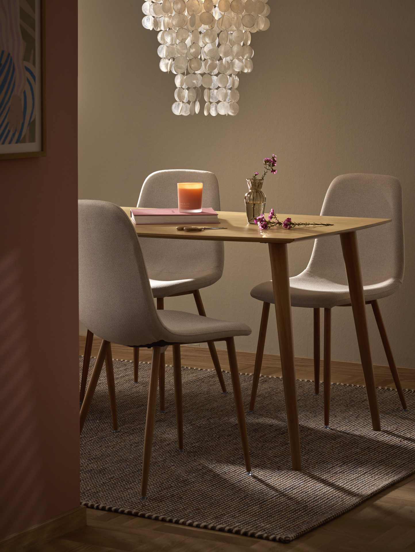 Ett båtformat ekbord och stolar i beiget tyg.