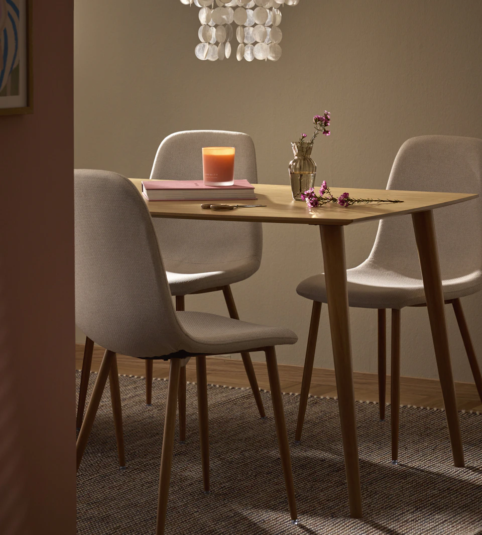 Ett båtformat ekbord och stolar i beiget tyg.