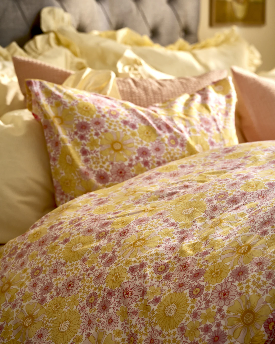  en säng bäddad med ett gult och rosa påslakan