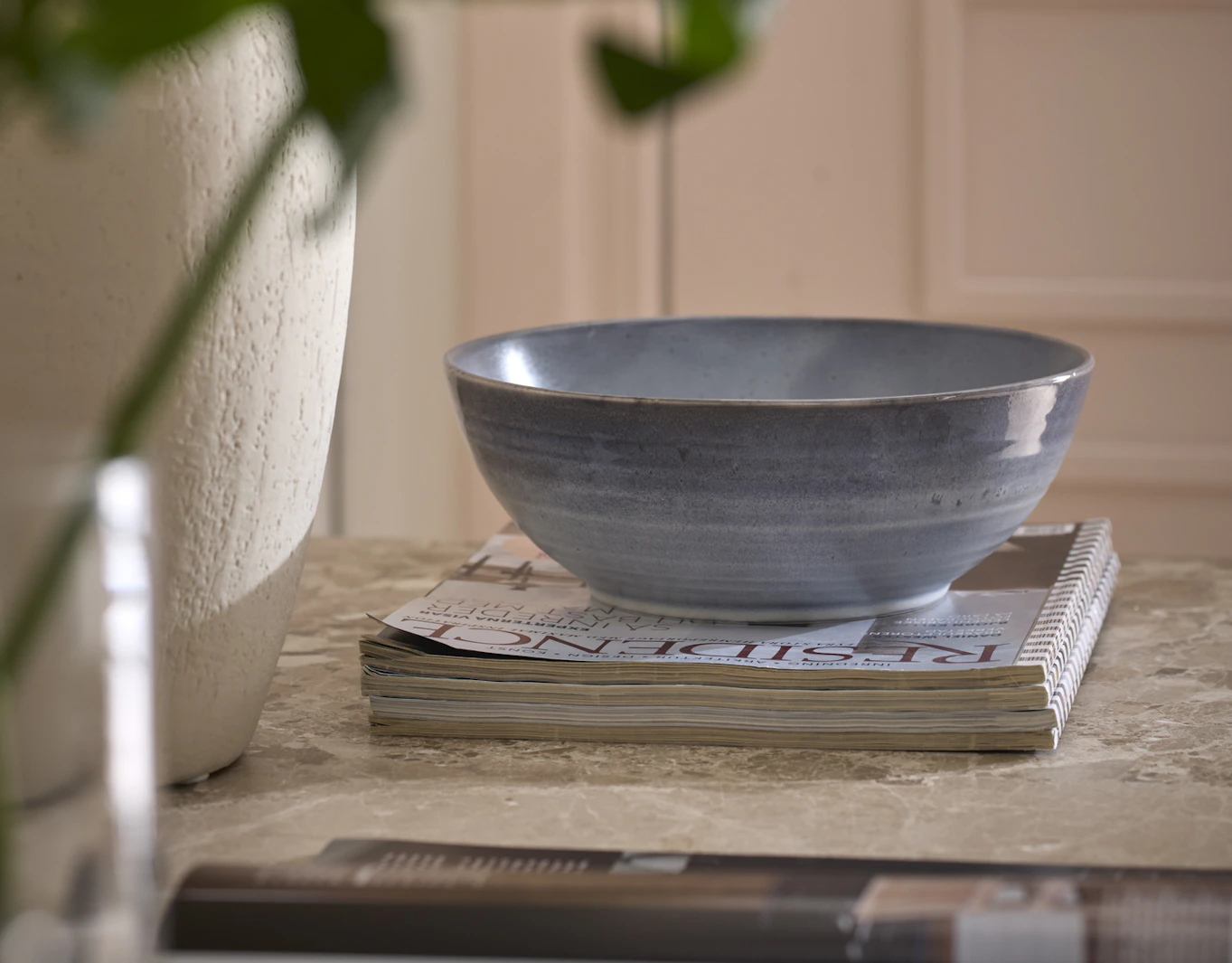 På en trave magasin står en skål från servisen Gotland.