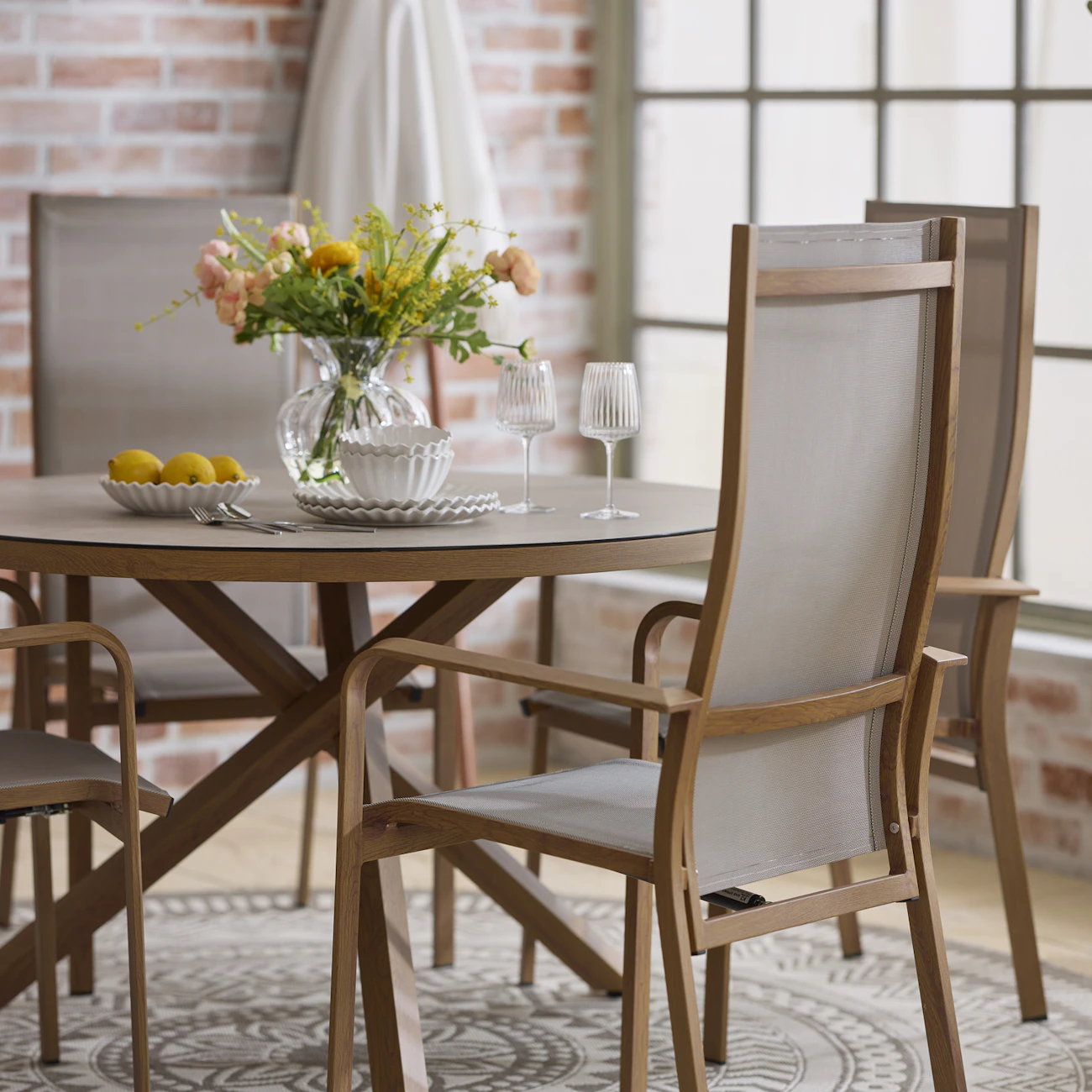 I ett orangeri står ett runt utebord i träimitation med fyra stolar