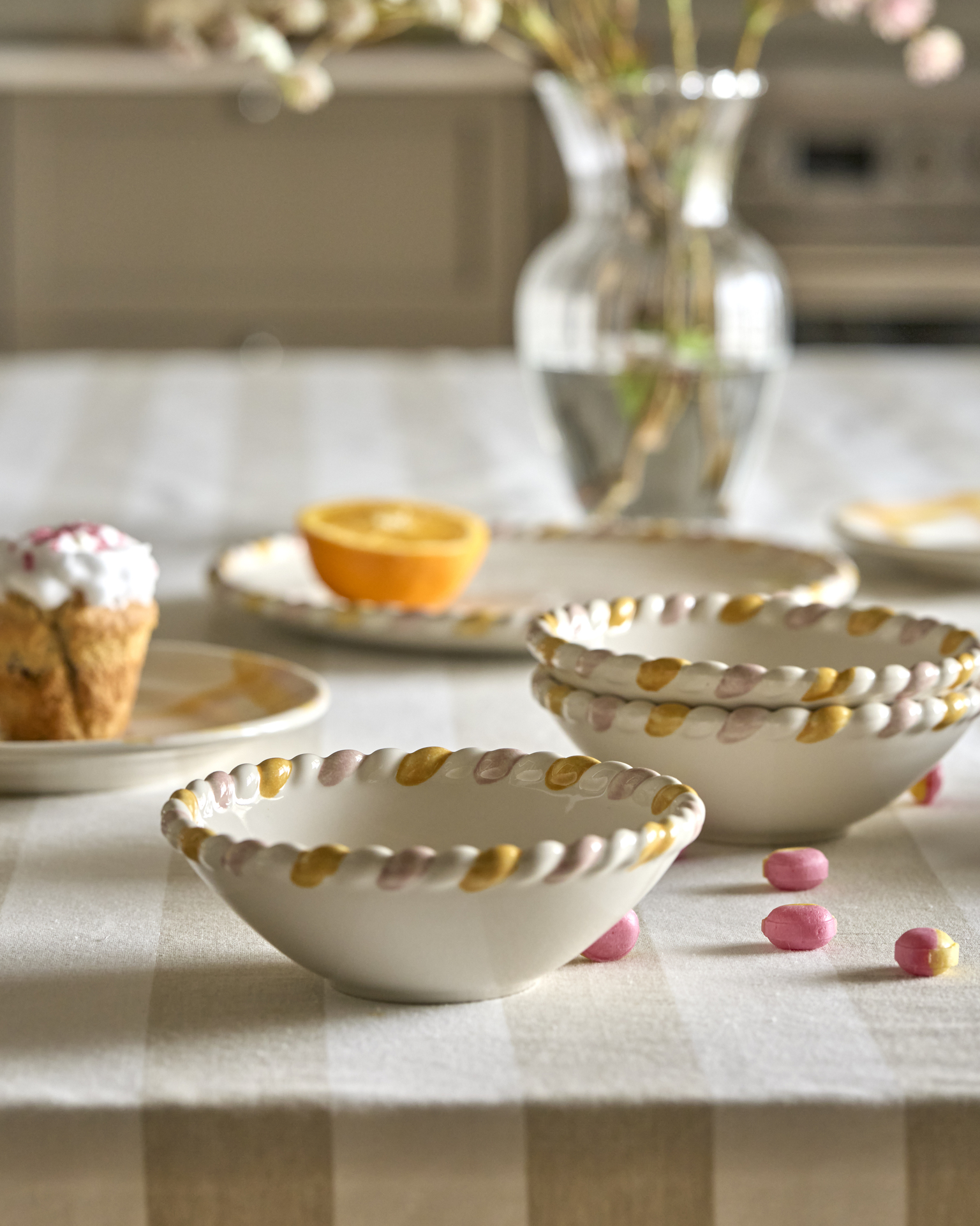 På en randig duk står skålar och tallrikar från servisen Alexia.