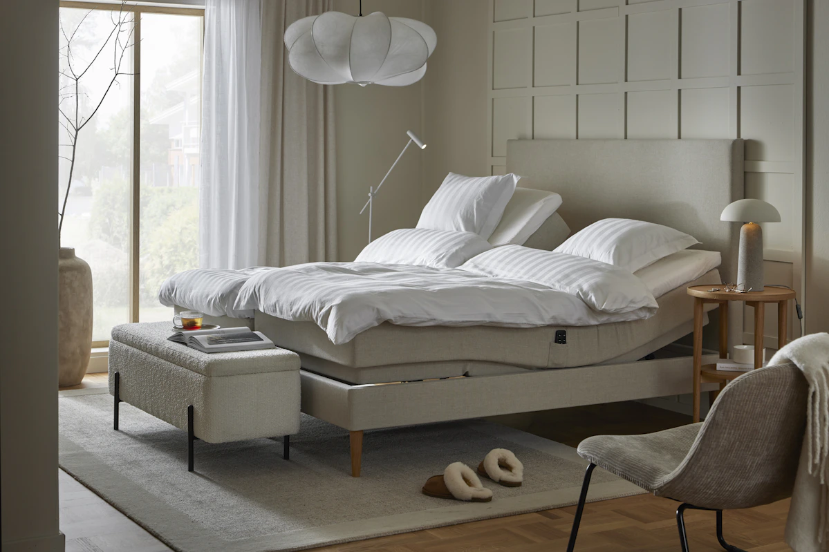 en beige ställbar säng i ett sovrum med beiga väggar