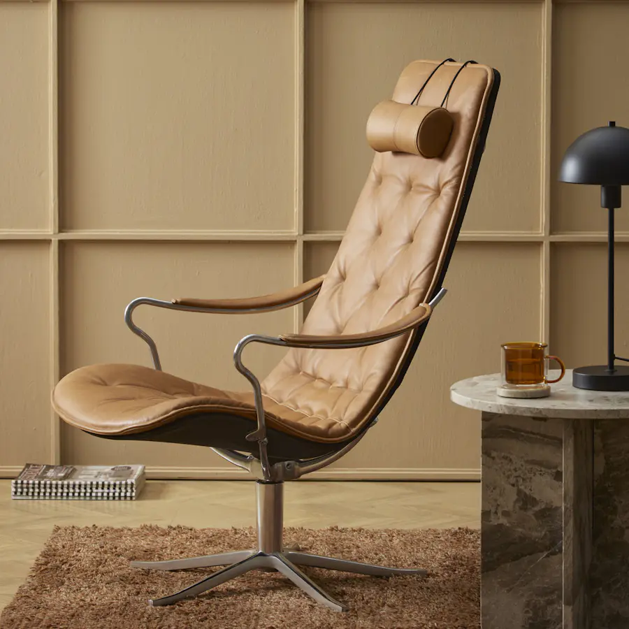 En brun läderfåtölj i modern retrodesign står i ett gult rum