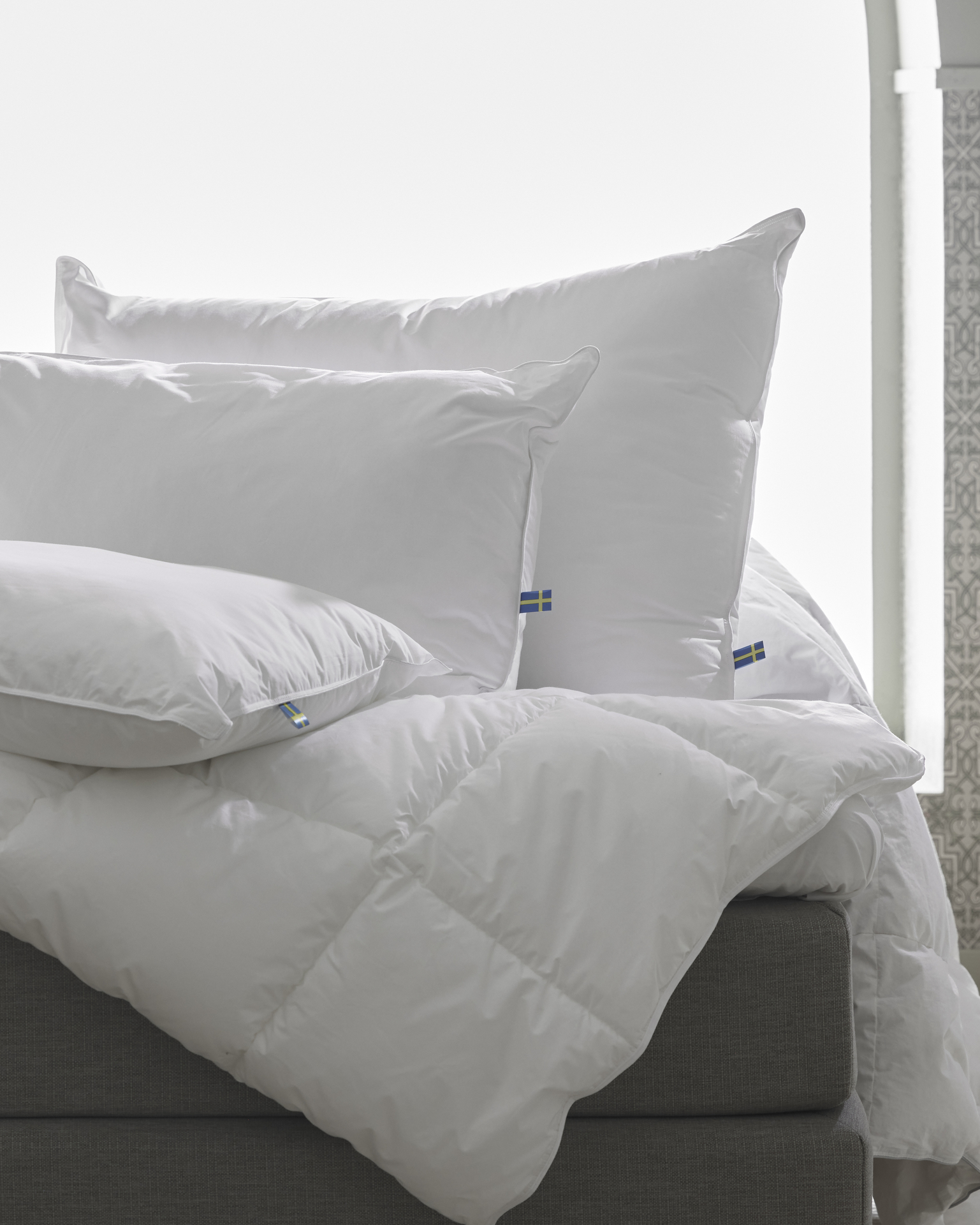 Tre hotellkuddar utan örngott är placerade på en säng.